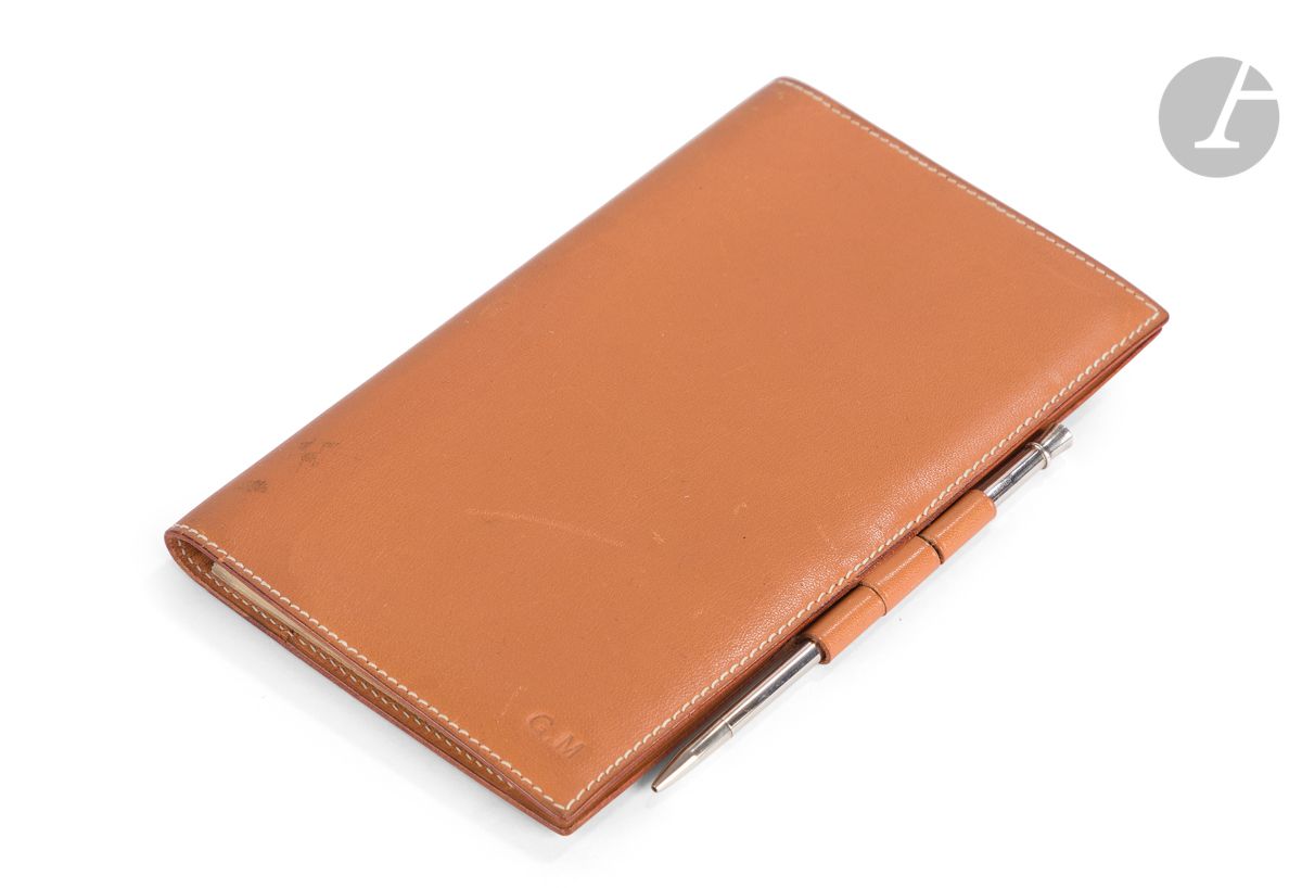 HERMES Paris Made in France
Couverture de répertoire en cuir gold, chiffré G.M (petites traces), répertoire et stylo en argent
17 x 10 cm