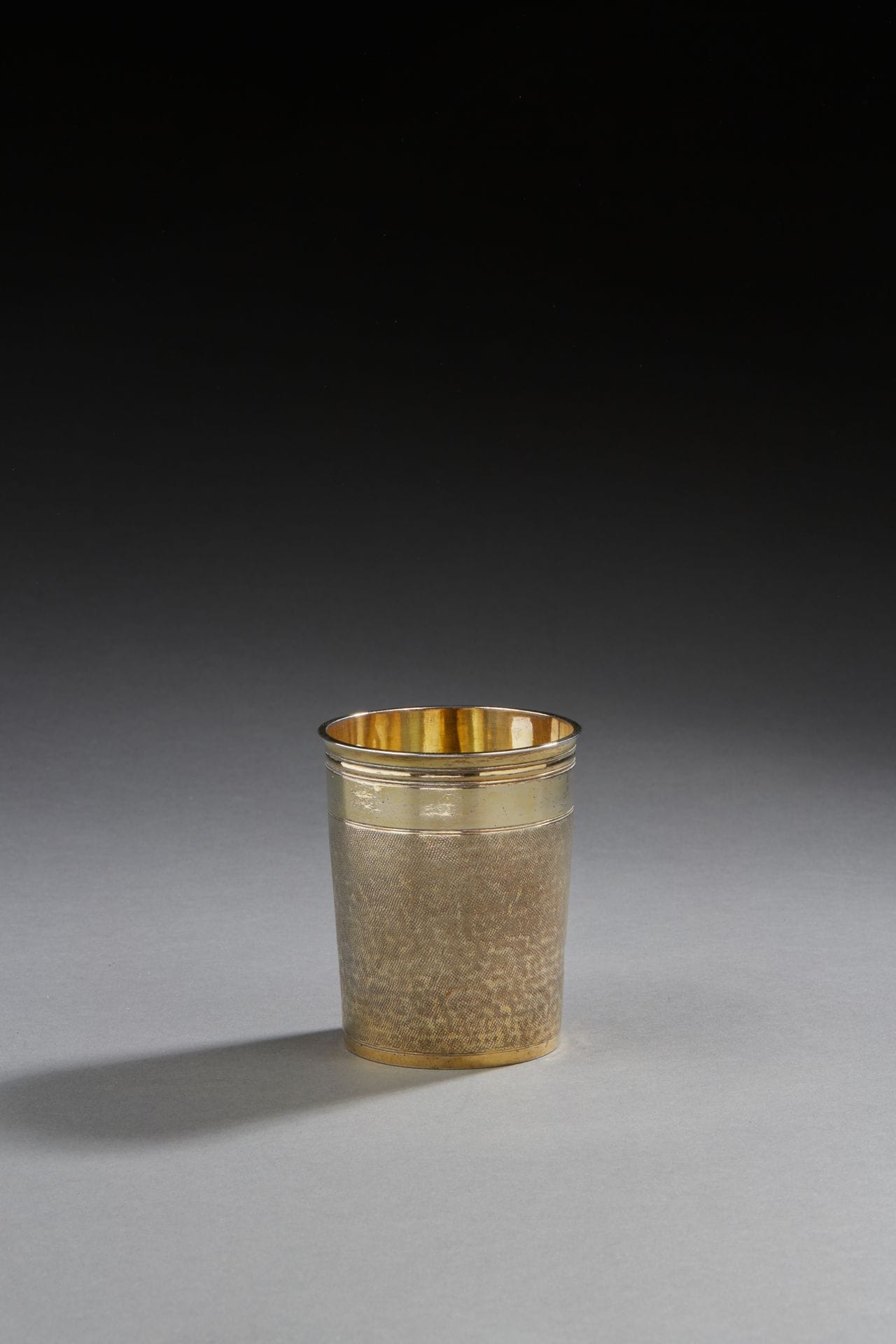 STRASBOURG END OF THE 17th CENTURY
Magistrate's cup in vermeil with a "shark skin" decoration between two plain bands, the border moulded with fillets. On the bottom engraving of the coat of arms of the city of Ribeauvillé in a laurel leaf dated 1689. 
 Weight: 179.8 g - height: 9.4 cm
Marked: no master goldsmith's mark, trace of a mark on the second cock
Condition: three slight bumps on the amati background, condition of the vermeil

Bibliography: 
Identical model in the book Deux siècles d'orfèvrerie à Strasbourg, in the collections of the Musée de Colmar under number 7 of the catalogue.
HAUG (H.), 1064, illustration p.109 - HAUG (H.), 1978, n°60. Inventory XXXVII,25.
For this model : Exhibition : 1964, Paris, n° 8
STRASBOURG END OF THE 17th CENTURY
A vermeil magistrate's beaker 
Hallmark: No master silversmith's hallmark, trace of the second rooster hallmark