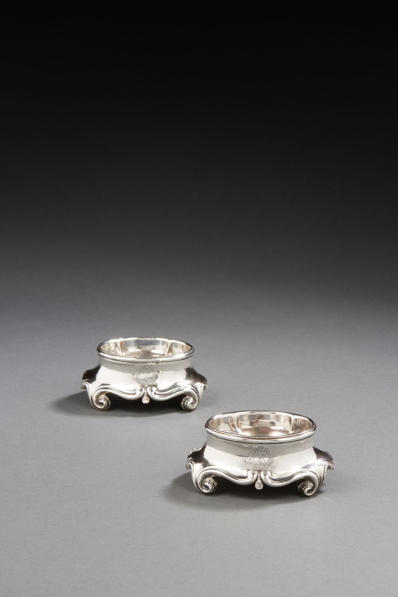 TOULOUSE 1757
Pair of saltcellars in melted silver, oval shape, standing on four scrolled feet. They are engraved on one side with a coat of arms in a rocaille frame.
Master silversmith: Pierre II DESNOS, received in 1740
Weight : 220,8 g - length : 7,7 cm - width : 5,8 cm - height : 3,7 cm
TOULOUSE 1757
A pair of cast silver salt shakers 
Master silvermith: Pierre II DESNOS