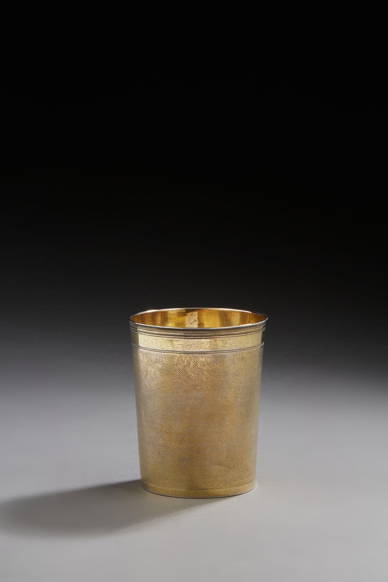 STRASBOURG 1634 - 1639
A vermeil beaker with a "shark skin" decoration between two plain bands, the edge moulded with fillets.
Master silversmith: Daniel DIETRICH, received in 1634
Weight: 130,6 g - height: 9,3 cm
STRASBOURG 1634 - 1639
A vermeil beaker 
Master silversmith: Daniel DIETRICH