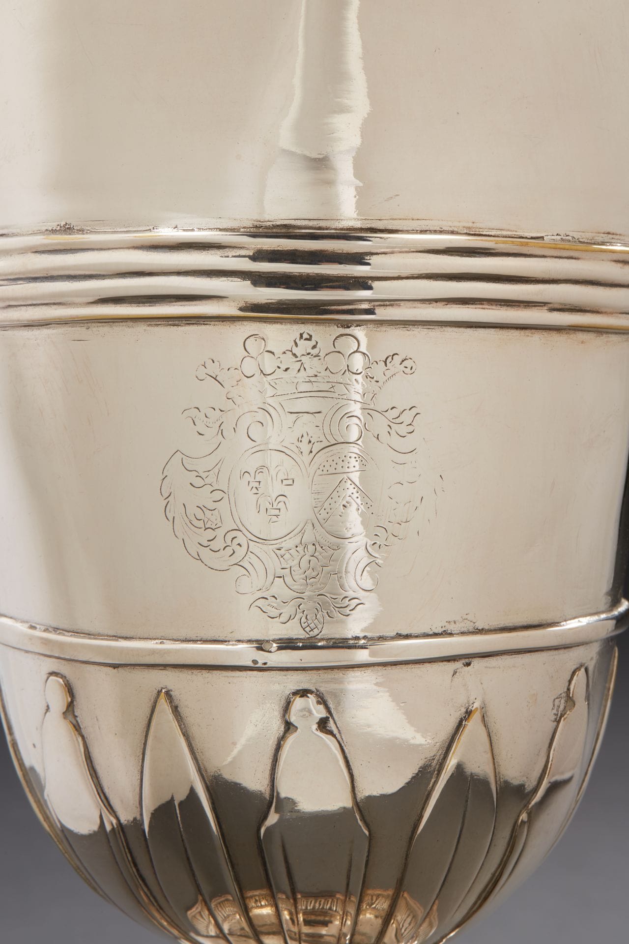 FRANCE 18th CENTURY
A plated metal (resilvered) helmet ewer resting on a circular pedestal bordered with gadroons, the body enhanced with lanceolate appliques, then with an engraved coat of arms surmounted by a marquis crown between two rows of fillets.
Height : 28,5 cm
FRANCE 18TH CENTURY
A plated metal (resilvered) helmet ewer