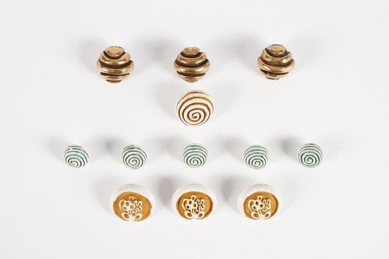 Line VAUTRIN (1913-1997)
Lot de douze boutons en céramique émaillée. Cinq boutons « Spirale » vert et blanc, non signés. D.: 1,8 cm. Modèle reproduit dans l'ouvrage « Line Vautrin, bijoux et objets » par Line Vautrin & Patrick Mauriès. Editions Thames & Hudson 1992. Un bouton « Spirale » ocre et blanc, non signé. D.: 2,6 cm Modèle reproduit dans l'ouvrage « Line Vautrin, bijoux et objets » par Line Vautrin & Patrick Mauriès. Editions Thames & Hudson 1992. Trois boutons ronds, marron et or, non signés. D.: 2,3 cm. Trois boutons ocre et blanc, non signés. 2,8 x 2,5 cm.