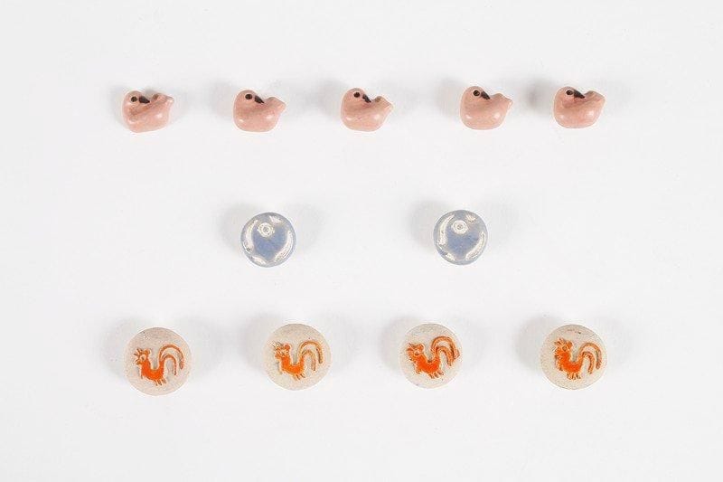 Line VAUTRIN (1913-1997)
Lot de onze boutons en céramique émaillée. Cinq boutons « Canard », non signés. D.: 1, 9 cm. Modèle reproduit dans l'ouvrage « Line Vautrin, bijoux et objets » par Line Vautrin & Patrick Mauriès. Editions Thames & Hudson 1992. Quatre boutons « Coq » orange, monogrammés. D.: 2,5cm. Modèle référencé sur le site dédié à l'artiste. Deux boutons « Poisson » bleus, monogrammés. D.: 2 cm. Modèle référencé sur le site dédié à l'artiste.