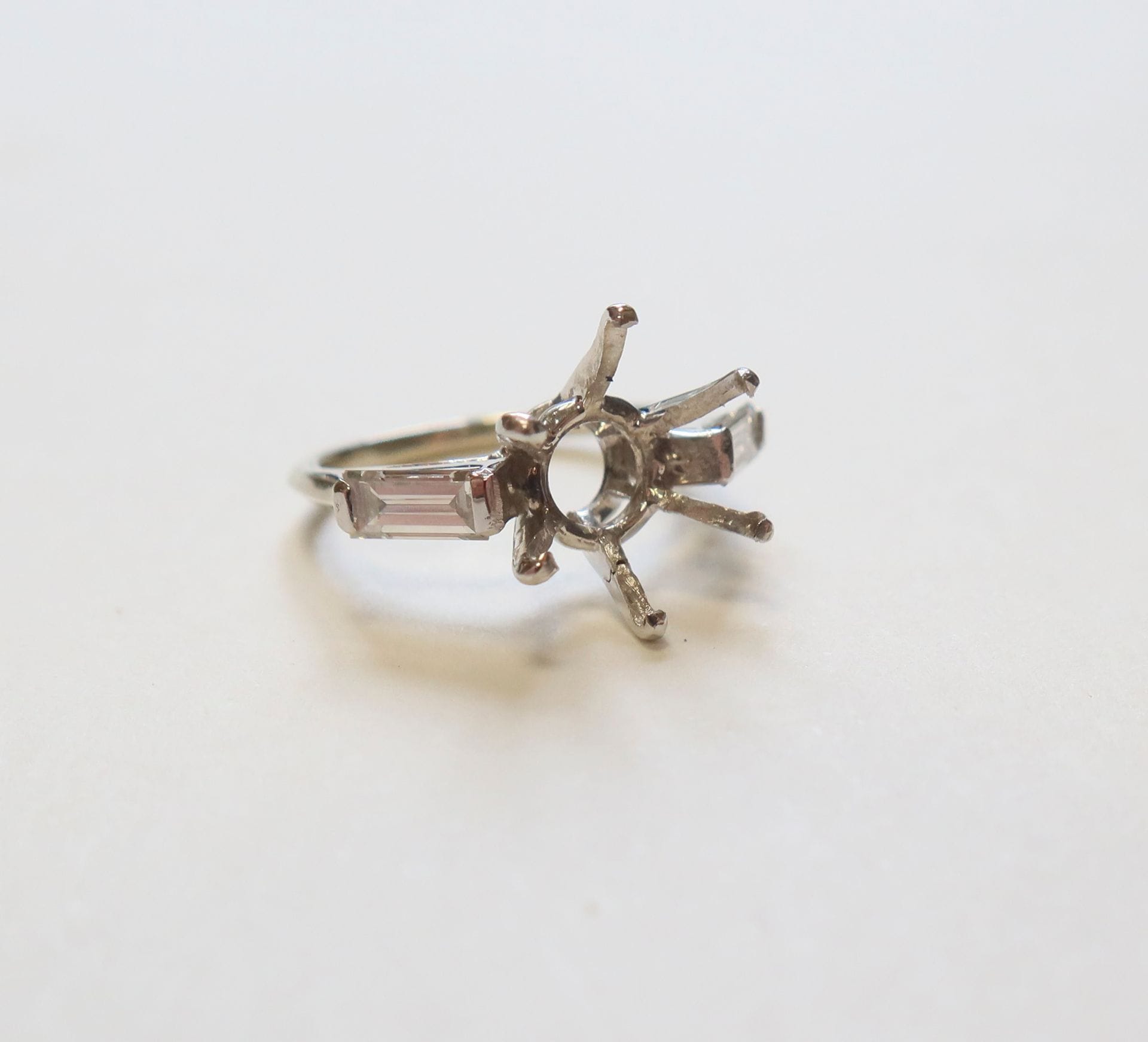 
Monture de bague en or (18K) sertie clos de deux baguettes en brillant. 

(1 griffe cassée)

Poids brut : 2, 9 g.



T:46
