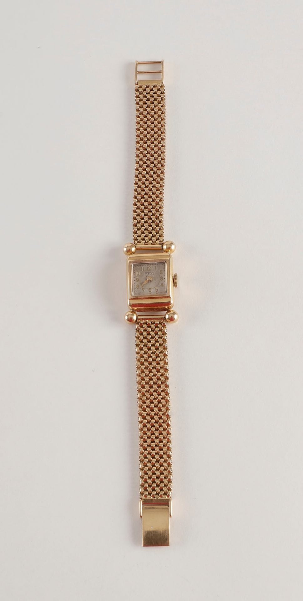 Bracelet montre de dame en or (18K)  jaune maillons articulés. 
Boitier carré signé RECO
Poids brut : 39,2 g