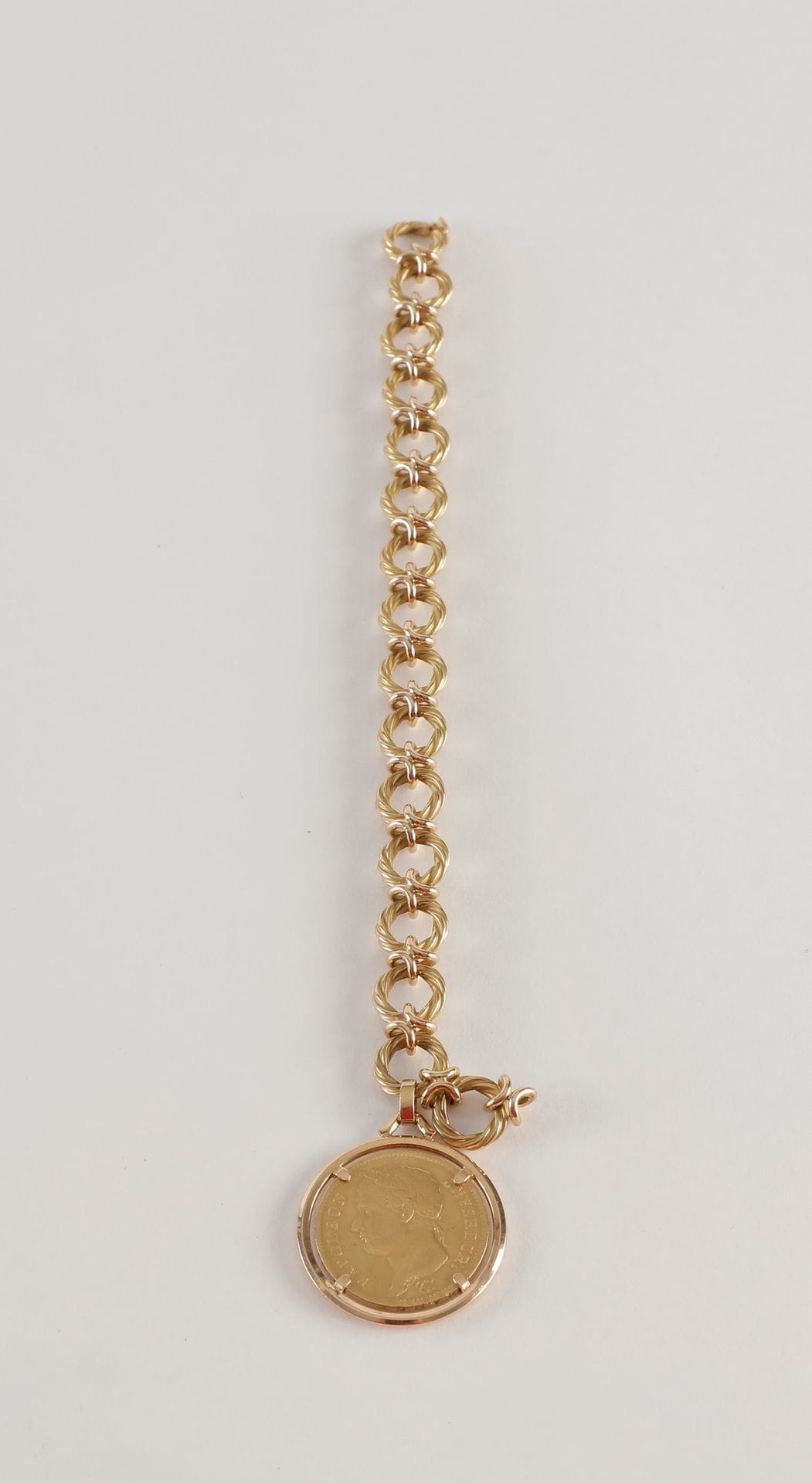 Bracelet en or (18K) maillons torsadés retenant en pendeloque une pièce de 40 Francs or (22K).
Type Napoléon Empereur. 1811 A
Poids : 59,7 g