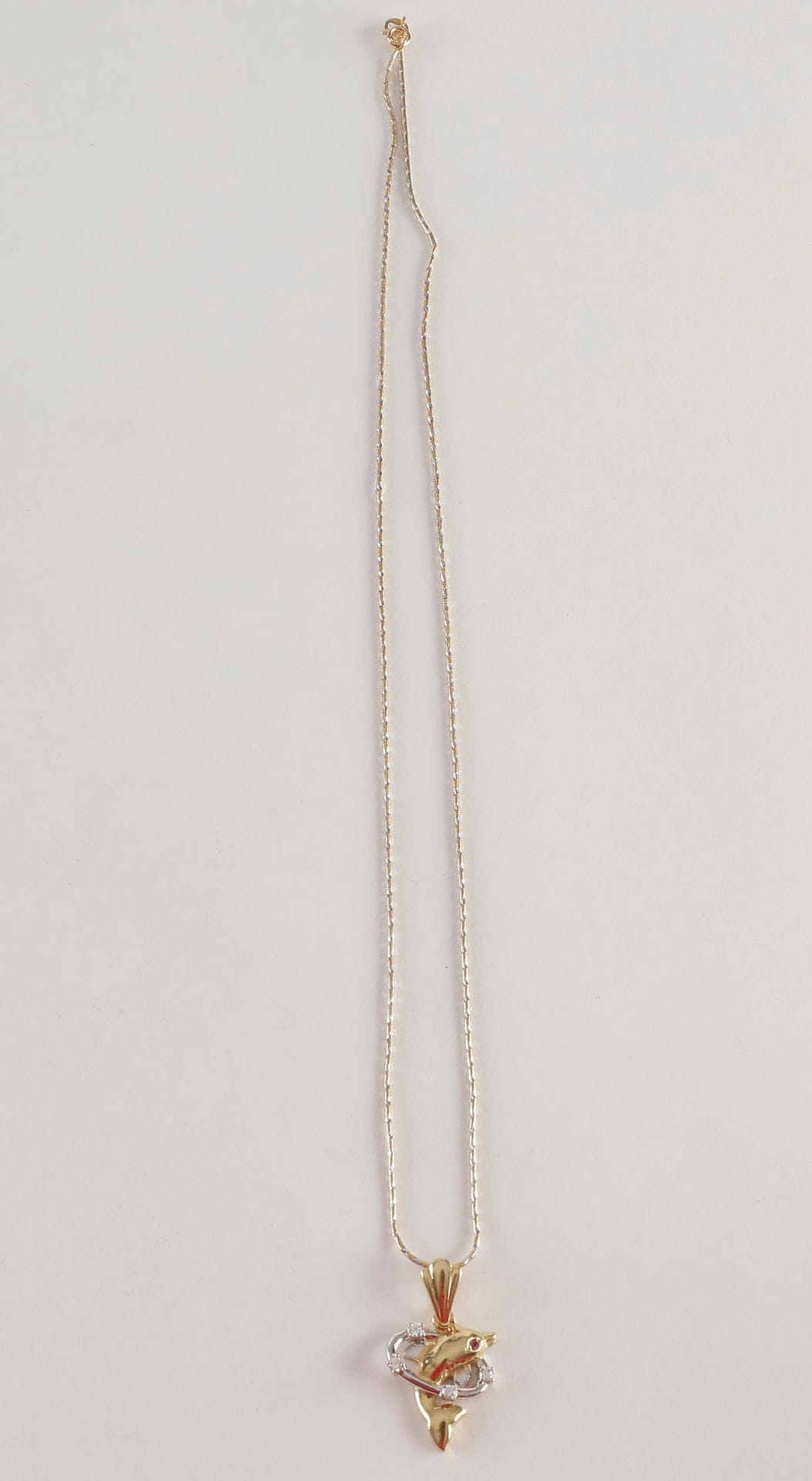 Pendentif dauphin et sa chaine en or (18K). Poids brut: 8.9 g
