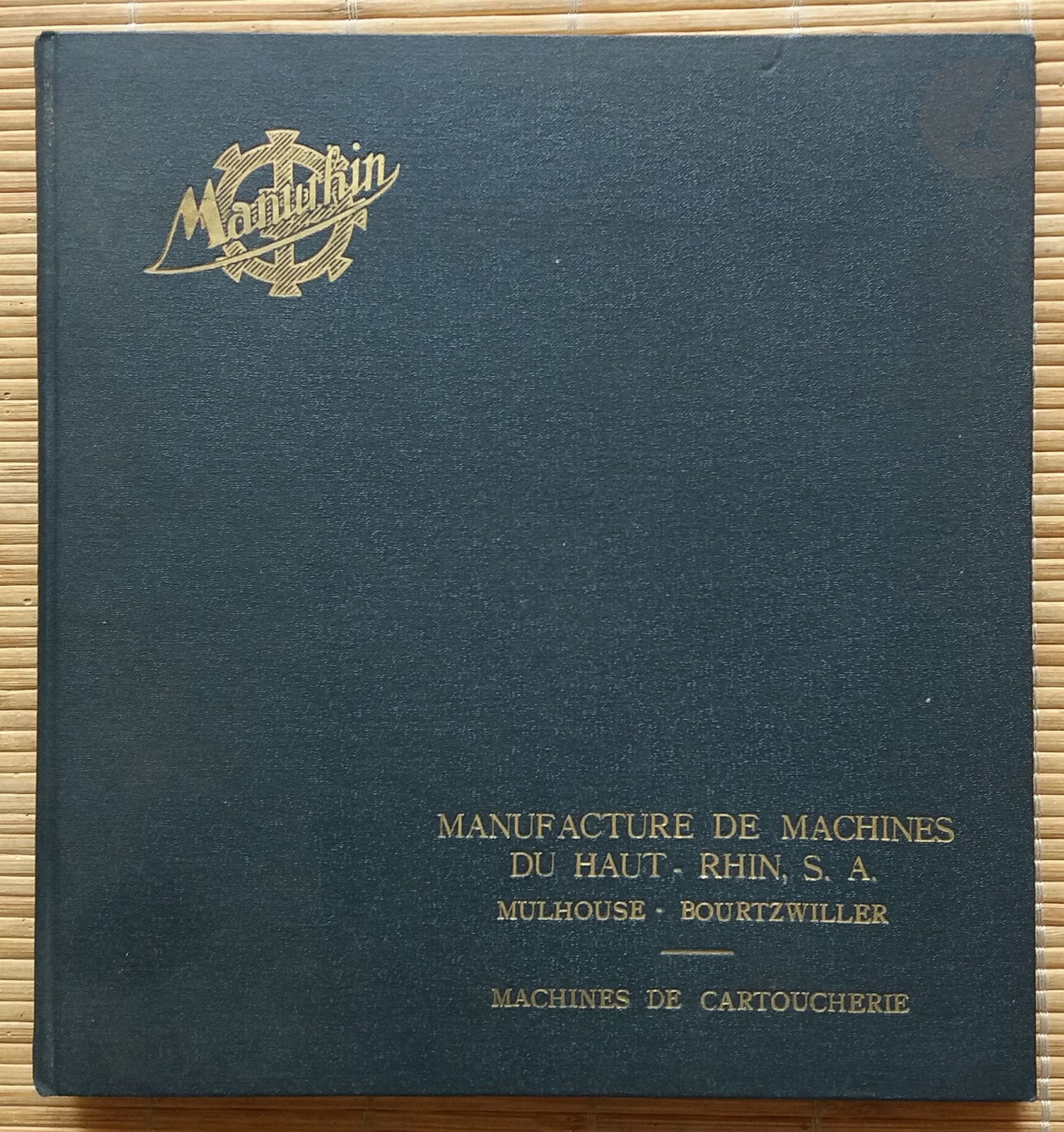 LIVRE D'ENTREPRISE
Manurhin.
Machines de Cartoucherie.
Manufacture de Machines du Haut-Rhin, Mulhouse-Bourtzwiller, s.d.
In-8 (21 x 23 cm). Édition originale, sans date. 72 pages. Catalogue n°38. Page de titre suivie d'un photomontage aérien de l'usine. Descriptions des machines de fabrication des étuis, des balles et des cartouches, accompagnées pour chaque fiche descriptive d'un tirage original représentant ladite machine. Format des tirages 14 x 10,5 cm. Les tirages sont glissés entre les pages et non pas collés. Ensemble complet de tous les tirages. Reliure rigide noir avec emblème de l'entreprise et titre en lettres dorées. Très bel état.