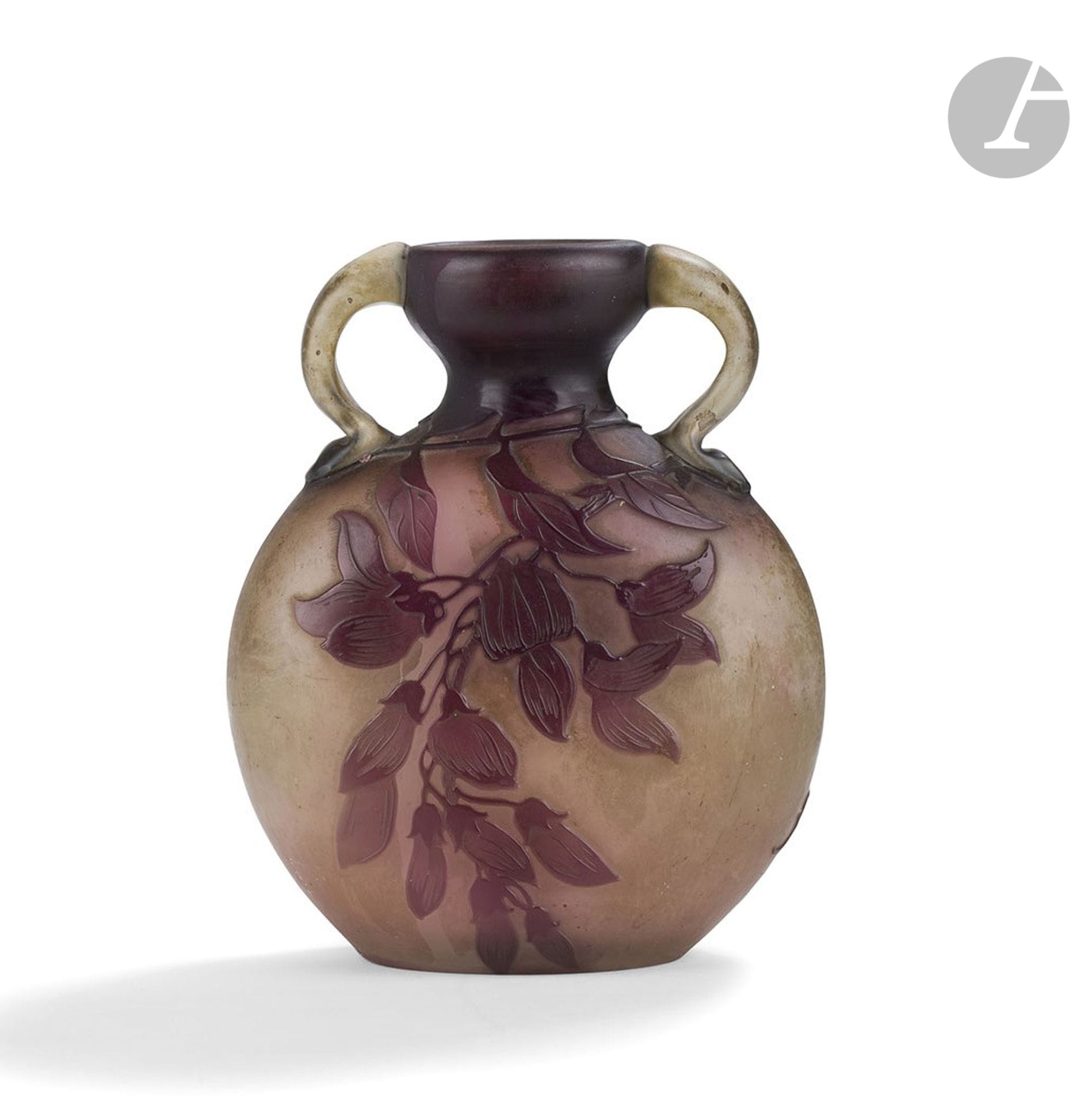 ÉTABLISSEMENTS GALLÉ (1904-1936)
Glycine
Gourde méplate à deux anses modelées et collées à chaud. Épreuve en verre multicouche au décor dégagé à l’acide et traité violet sur fond gris-blanc nuancé de rose vers la base. Deux reprises à la meule sur une des faces très probablement d’origine. Signé GALLÉ, en réserve gravé en camée à l’acide. H. 14 cm