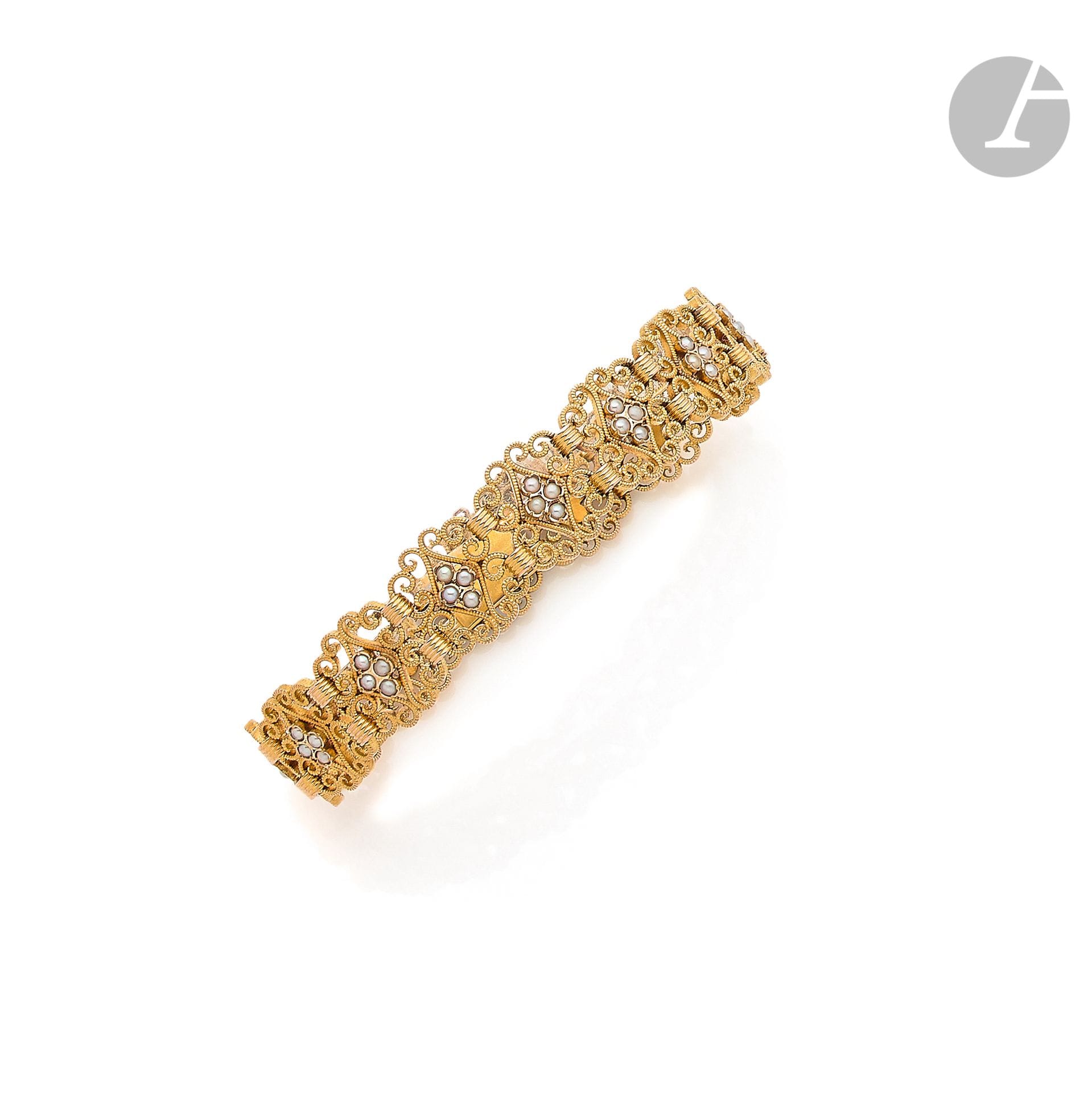 Bracelet en or 18K (750), articulé de maillons filigranés agrémentés de demi-perles. Travail français de la seconde moitié du XIXe siècle. Conservé dans son écrin. Dimensions : 1,3 x 18 cm environ. Poids brut : 27,3 g



A french 19th century bracelet
