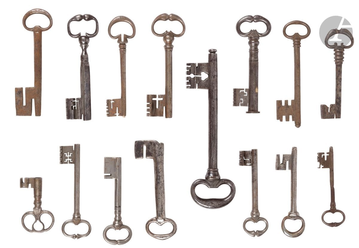 Lot de 15 clefs en fer forgé des XVIIe et XVIIIe siècles
La plupart à anneaux à « cuisses de grenouilles », une avec son fourreau, une à panneton percé d’un trèfle, une à anneau à entrelacs, une à tige triangulaire, une à panneton en « S », une autre en « J ».