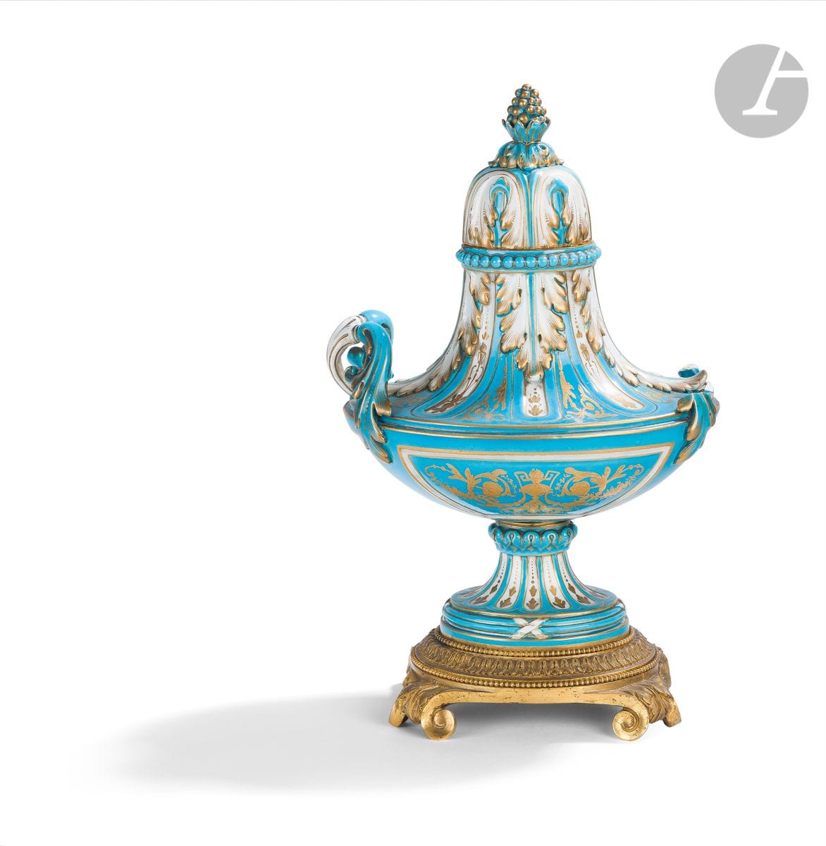 Sèvres (genre de)
Cassolette couverte en porcelaine tendre et bronze doré, à décor en or de vases flammés et rinceaux feuillagés sur fond bleu céleste, la base en bronze doré de style Louis XVI.
Deuxième moitié du XIXe siècle. 
H : 30 cm, L : 18 cm
Une anse cassée et manquante.