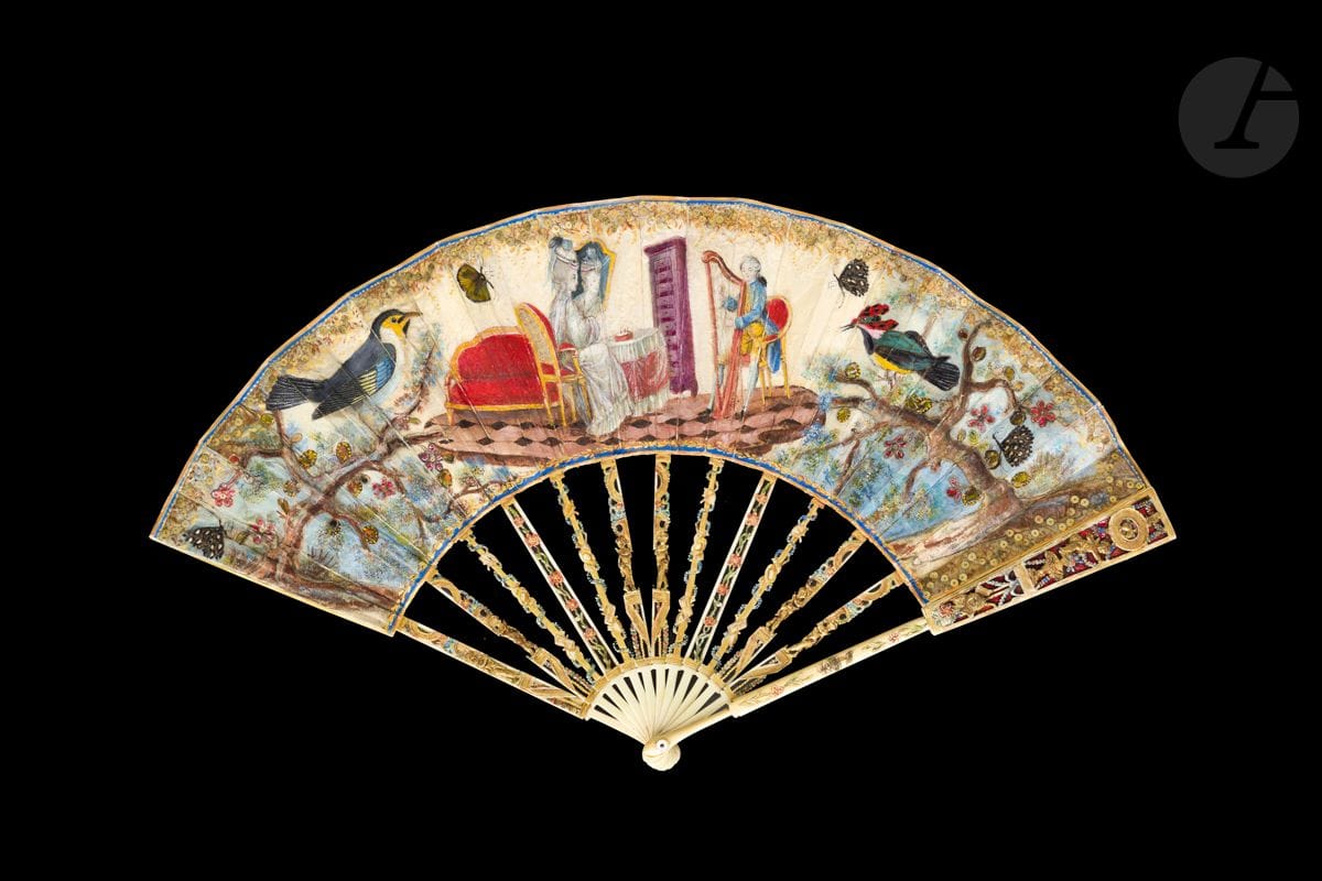 Le galant joueur de harpe, Europe, vers 1770-1780
Éventail plié, la feuille en soie crème peinte d’une dame de qualité devant sa table de toilette écoutant un galant jouer de la harpe. Les visages sont en papier découpé et rapporté. Quatre papillons aux ailes exécutées en plumes de faisan rapportées ornent les côtés de la composition, avec deux oiseaux gigantesques aux plumages colorés. 
Revers muet.
Monture en ivoire* découpé, gravé et peint en couleurs d’amours et de symboles champêtres.
H.t. 27,5 cm-H.f. 12,5 cm (usures, importantes restaurations) 
Poids brut : 67 g