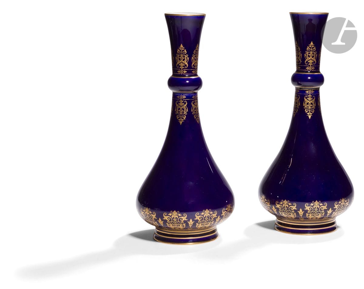 Sèvres
Paire de vases bouteille nommés vases Delhy en porcelaine à décor de rinceaux feuillagés en or dans le style mauresque sur fond bleu.
Marqués S. 74 et S. 80 en vert et RF doré à Sèvres 80 en rouge.
Fin du XIXe siècle, 1880.
H : 33 cm
Un éclat à une base.