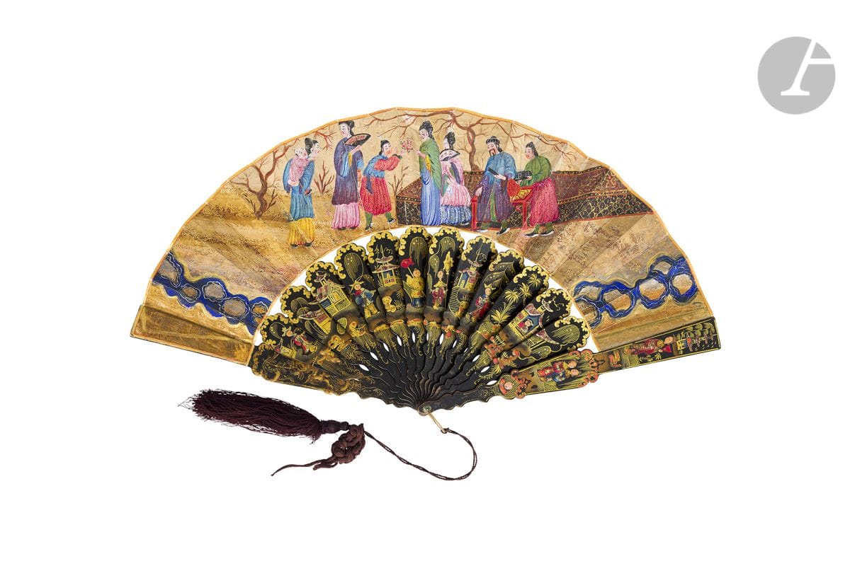 Voyage en Chine, Europe, vers 1850-1860
Éventail plié, la feuille double en papier peint à la gouache de personnages inspirés de la Chine, dans un jardin. 
Revers peint de fleurs sur fond argenté.
Monture en papier mâché à l’imitation du bois laqué noir, à décor en léger relief gouaché et doré de pavillons et personnages chinois.
Bélière métallique et gland de passementerie.
H.t. 27,8 cm-H.f. 10,9 cm (restaurations)
Dans une boite en bambou laqué noir à décor or de personnages dans un jardin.