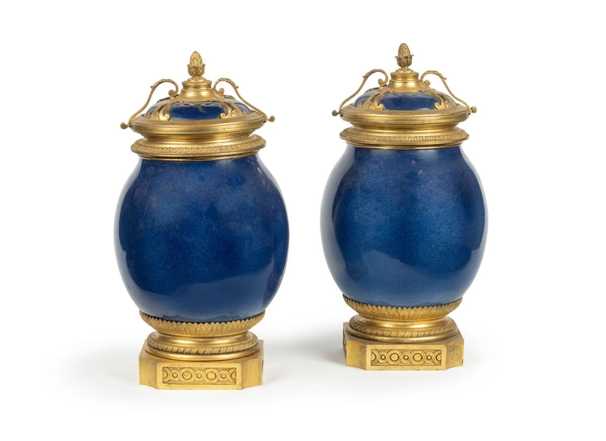 A pair of blue porcelain vases, the gilt bronze frame decorated with foliage, with a lid tilting on one side, released by a brace, resting on a base with ribboned rushes and interlacing.
Louis XVI style.
H : 42 cm

