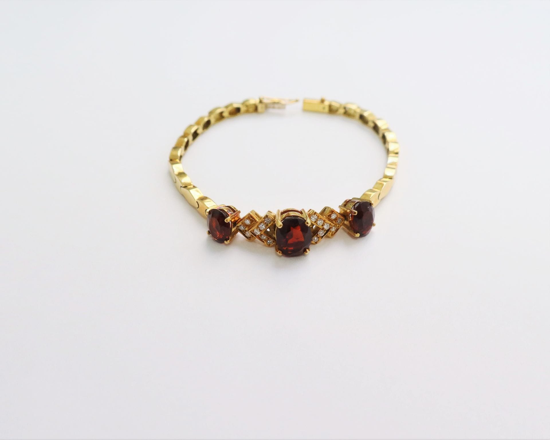 Bracelet en or 18K (750), serti de 3 pierres brunes ovales et de diamants 8/8. Longueur : 15,2 cm environ. Poids brut : 16,2 g