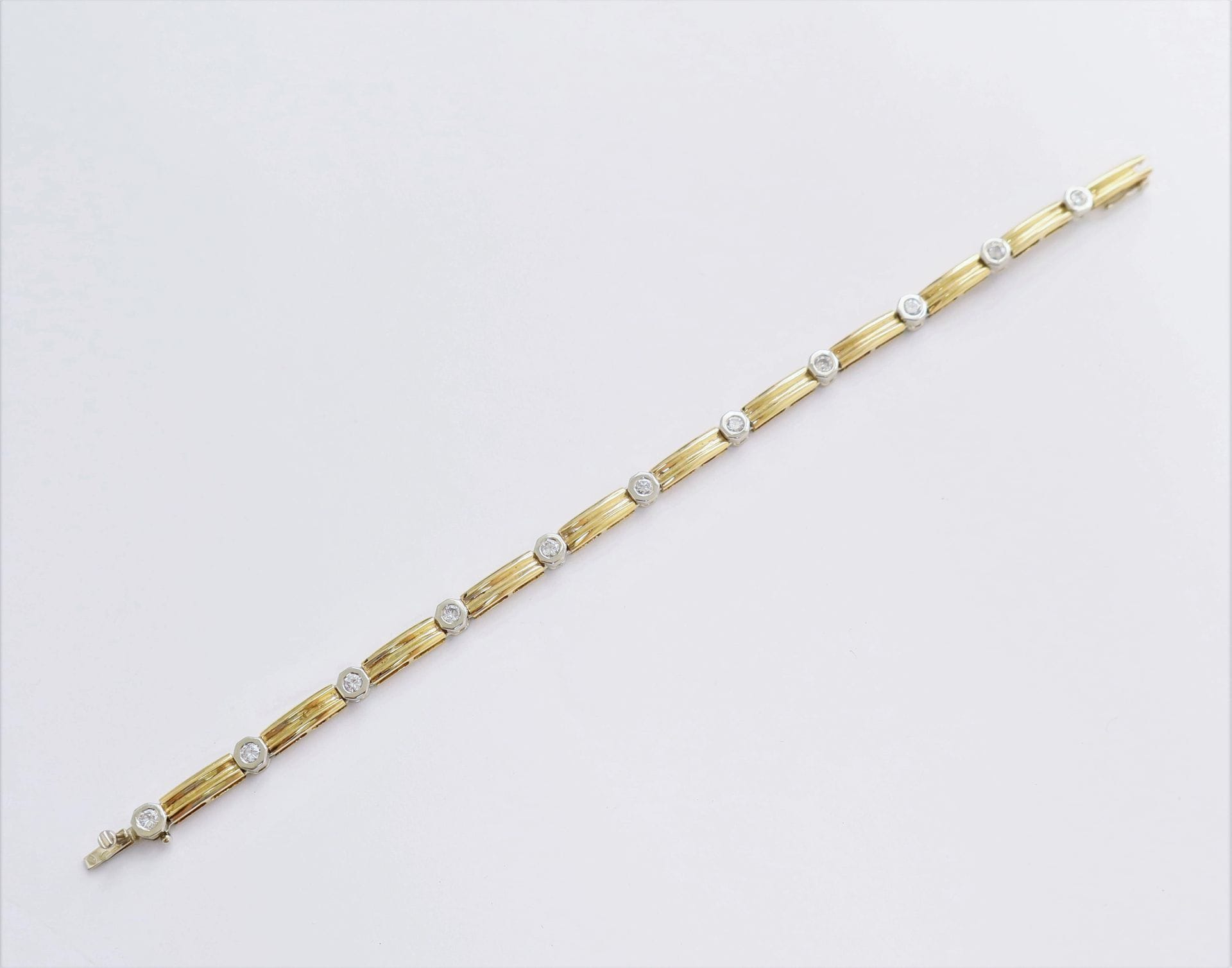 Bracelet en deux tons d'or 18K (750), orné de 11 diamants ronds de taille brillant. Longueur : 18 cm environ. Poids brut : 14,9 g