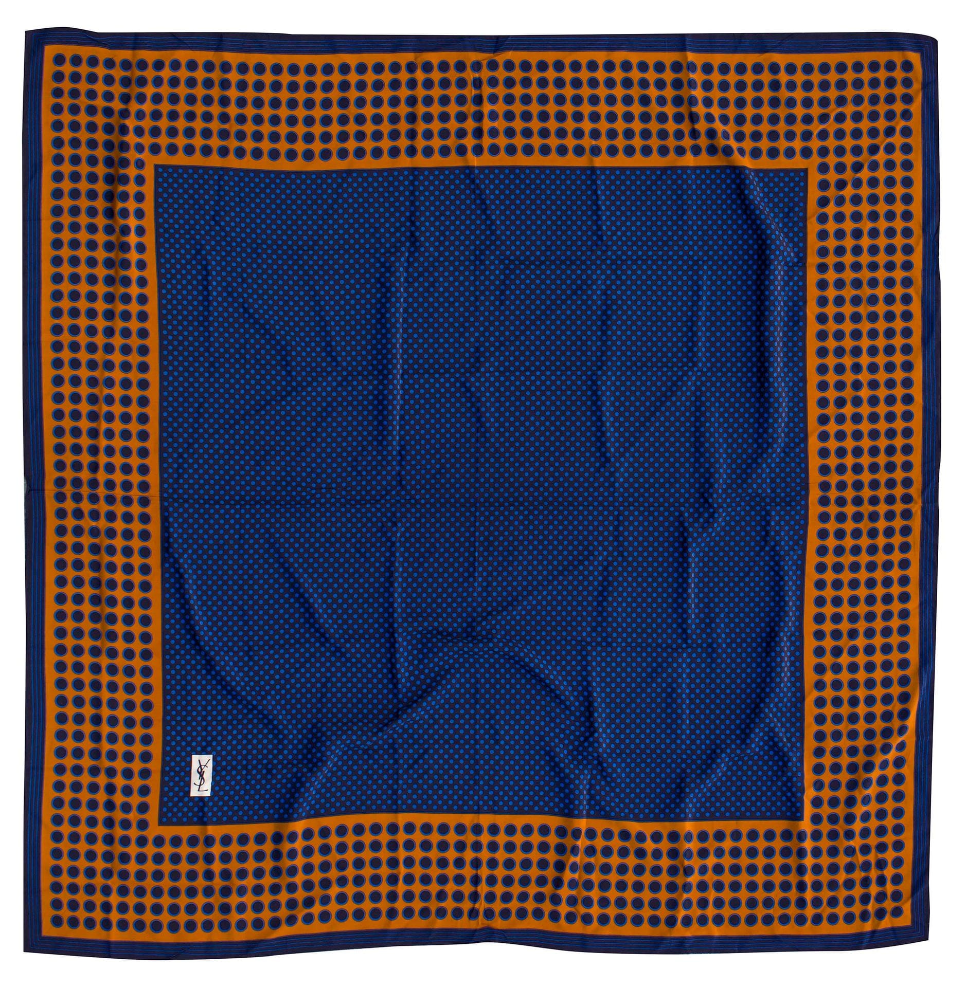 Yves SAINT LAURENT et Christian DIOR. Lot de deux foulards dont un châle carré en soie à décor de pois bleus sur fond marine et entourage tabac (YSL), et un foulard dans les tons bleus à décor de fleurs (Dior) (petites taches et petit accroc)