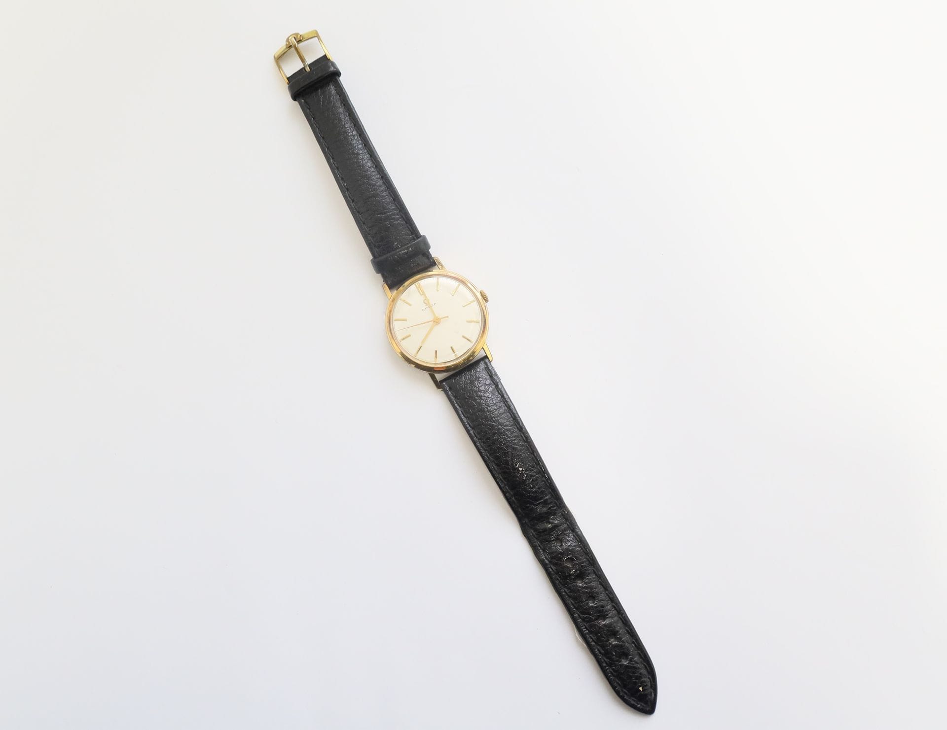 OMEGA 

Men's wristwatch in gilt metal, white dial, mechanical movement, leather strap.
