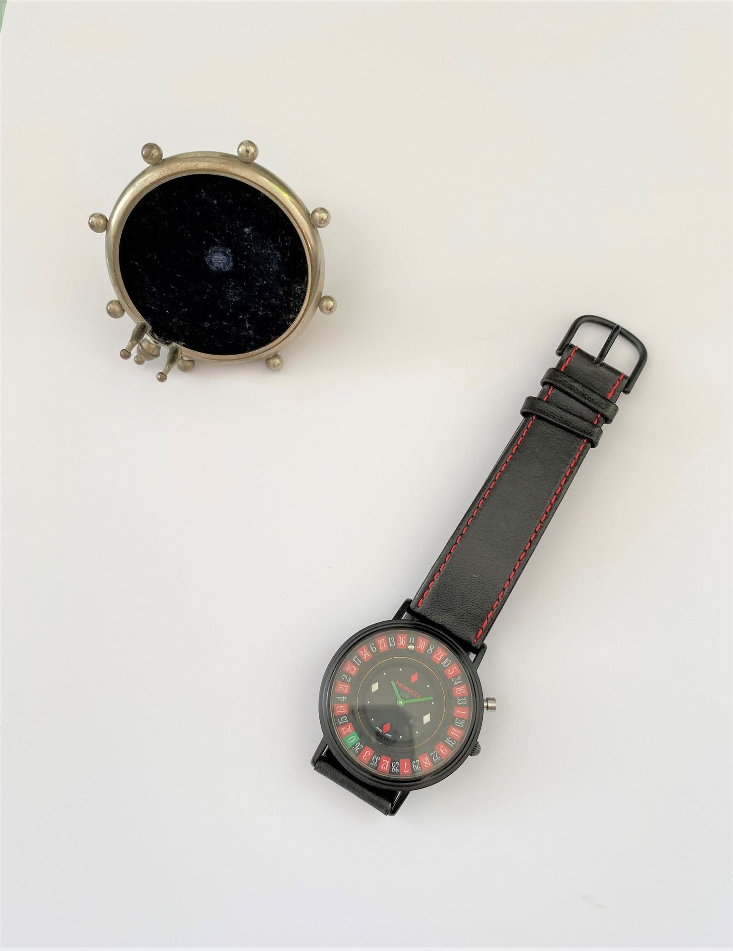 FIORUCCI. Steel man's wristwatch, the dial with casino roulette decoration. 

One joined a display of pocket watch out of metal