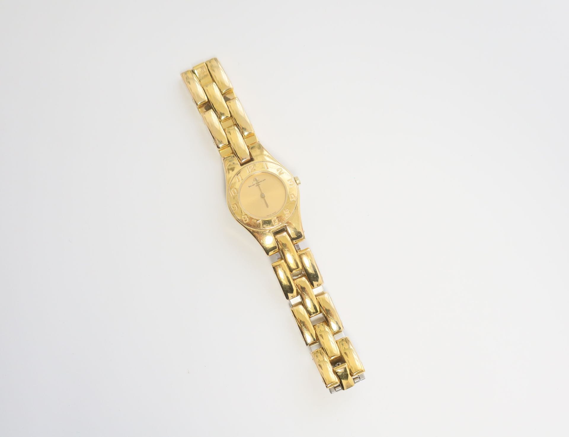 BAUME &MERCIER

N° 1858540

Ladies' gold metal wristwatch, gold dial, Roman numeral bezel forming the hours, quartz movement (battery not verified), signed gold metal bracelet.