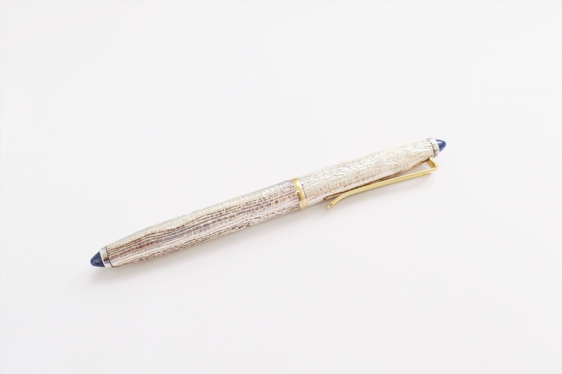 
PIERRE HUGO





Stylo plume en or 18K (750), le corps en métal gravé en écorce, les fins serties de sodalites cabochons, l'attache en métal doré. Signé. Dans son écrin. Poids brut : 47 g 