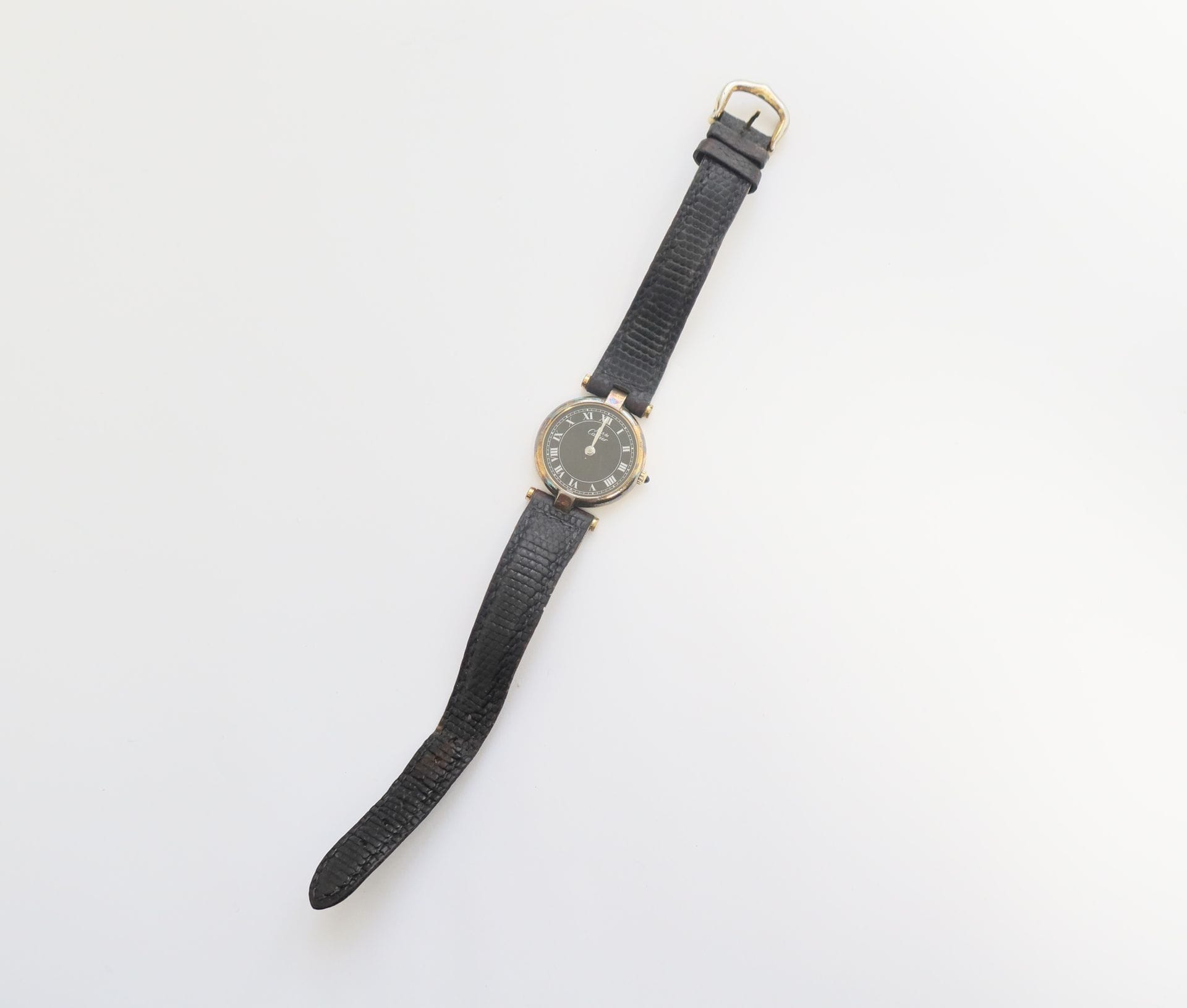 CARTIER Must 

N°18 025732

Ladies' wristwatch in silver vermeil (925), black dial, Roman numeral hour markers, quartz movement (battery not verified), leather strap (worn).