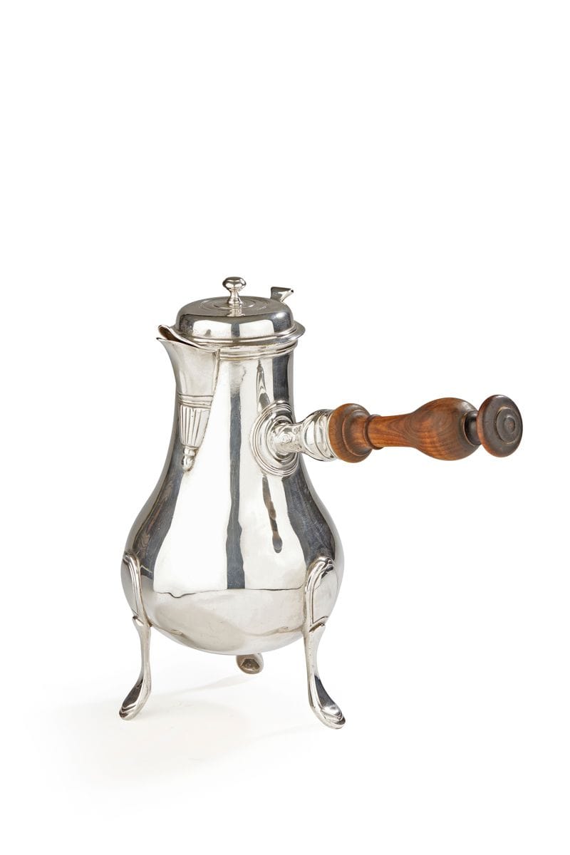 FRANCE XVIIIe SIÈCLE
Verseuse tripode anciennement en métal plaqué, les pieds à gradins et attaches en écusson. Le corps lisse, le bec verseur est rehaussé en partie médiane de lignes verticales terminées par une goutte, le bouton en toupie. Anse en bois latéral.
État : ancienne chocolatière, bouton poussoir soudé, et réargentée.
Hauteur : 26,2 cm