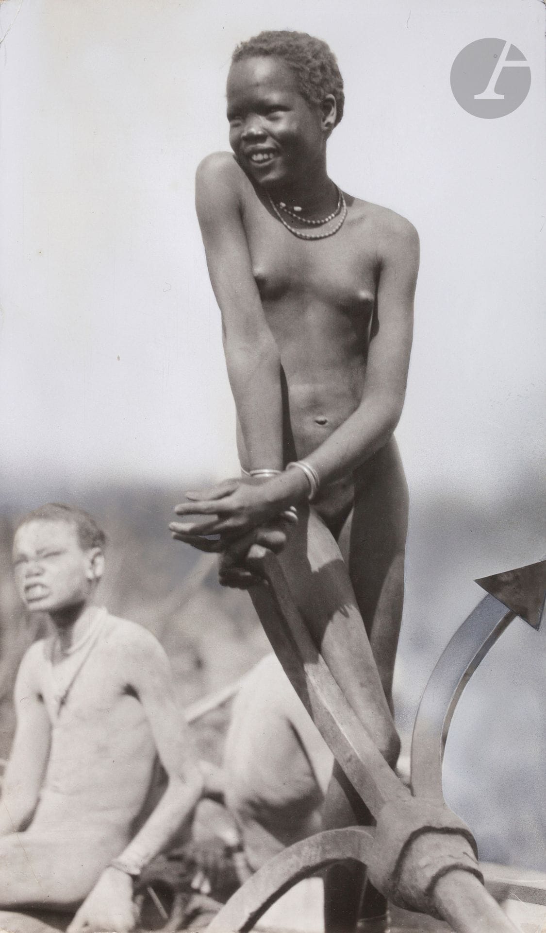 Hugo Bernatzik (1897 - 1953)  
Soudan. Peuple Nuer, 1927.  
Bahr el Zeraf. Jeunes filles Nuer. Joaillerie. Colliers en poils de girafe. Scarifications. Commerce. Coiffures traditionnelles. Cheveux colorés en rouge avec de l’argile, de la cendre de bois et de l’urine de vache. Femmes et fillettes construisant une embarcation. Pagne en fibre de palmier.  
17 épreuves argentiques d’époque. Quelques rehauts et indications de recadrage sur certaines épreuves. Nombreux tampons du photographe « Copyright - Hugo Adolf Bernatzik - Vienna - Austria » et « Copyright by Dr. Hugo A. Bernatzik - Wien », indications de recadrage, numéros de négatifs, annotations manuscrites et légendes tapuscrites sur étiquettes contrecollées aux versos.  
Formats : de 18 x 12 à 24 x 17 cm

Hugo Bernatzik (1897-1953) 
Sudan. Nuer people, 1927. 
Bahr el Zeraf. Nuer girls. Jewellery. Giraffe hair necklaces. Scarification. Trade. Traditional hairstyles. Hair coloured red with clay, wood ash and cow urine. Women and girls building a boat. Palm fiber loincloth. 
17 vintage gelatin silver prints. A few highlights and cropping marks on some prints. Numerous photographer's stamps "Copyright - Hugo Adolf Bernatzik - Vienna - Austria" and "Copyright by Dr. Hugo A. Bernatzik - Wien", cropping marks, negative numbers, handwritten annotations and typed captions on labels mounted on verso. 
Dimensions: from 18 x 12 to 24 x 17 cm