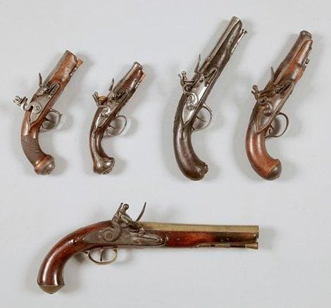 Pistolet de voyage à silex. Canon à pans, gravé. Platine et chien col de cygne à corps plat. Garnitures en fer. Crosse en noyer quadrillé. Baguette en bois. B.E. Vers 1780.