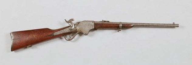 Carabine Spencer modèle 1865 un coup, calibre 50. Canon rond avec hausse. Bloc de culasse marqué "Model 1865. Spencer Repeating Rifle Pat D March 6 1860 Manuf D At Prov R.I. By Burnside Rifle Co.". Crosse en noyer verni. A.B.E. (Piqûres, guide d'anneau de selle coupé).