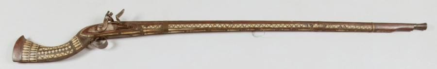 Fusil à silex afghan. Canon rond. Garnitures en fer. Crosse en noyer garni de morceaux d'os. E.M. XIXe siècle.