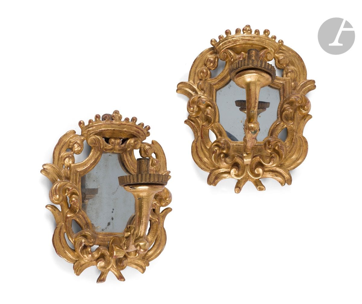 Paire de miroirs porte-lumière en bois et métal doré, à décor de feuillages ajouré surmontés d’une couronne, à un bras de lumière ; (accidents et restaurations).
XVIIIe siècle.
H : 37 cm, L : 29 cm