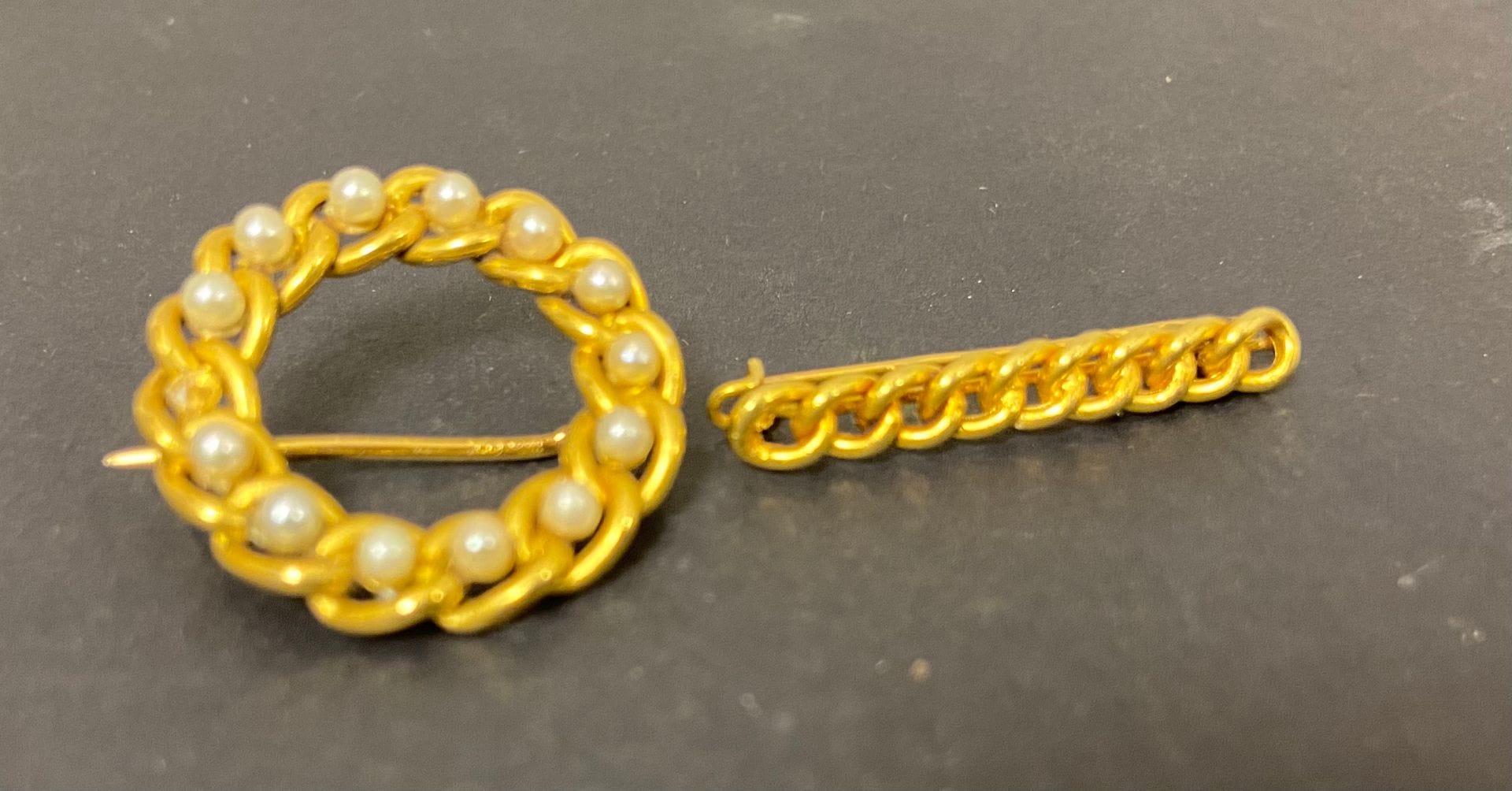Lot de deux broches "chaine gourmette" en or (18K) dont une avec perles.(22K). 
Poids brut: 3,5 g