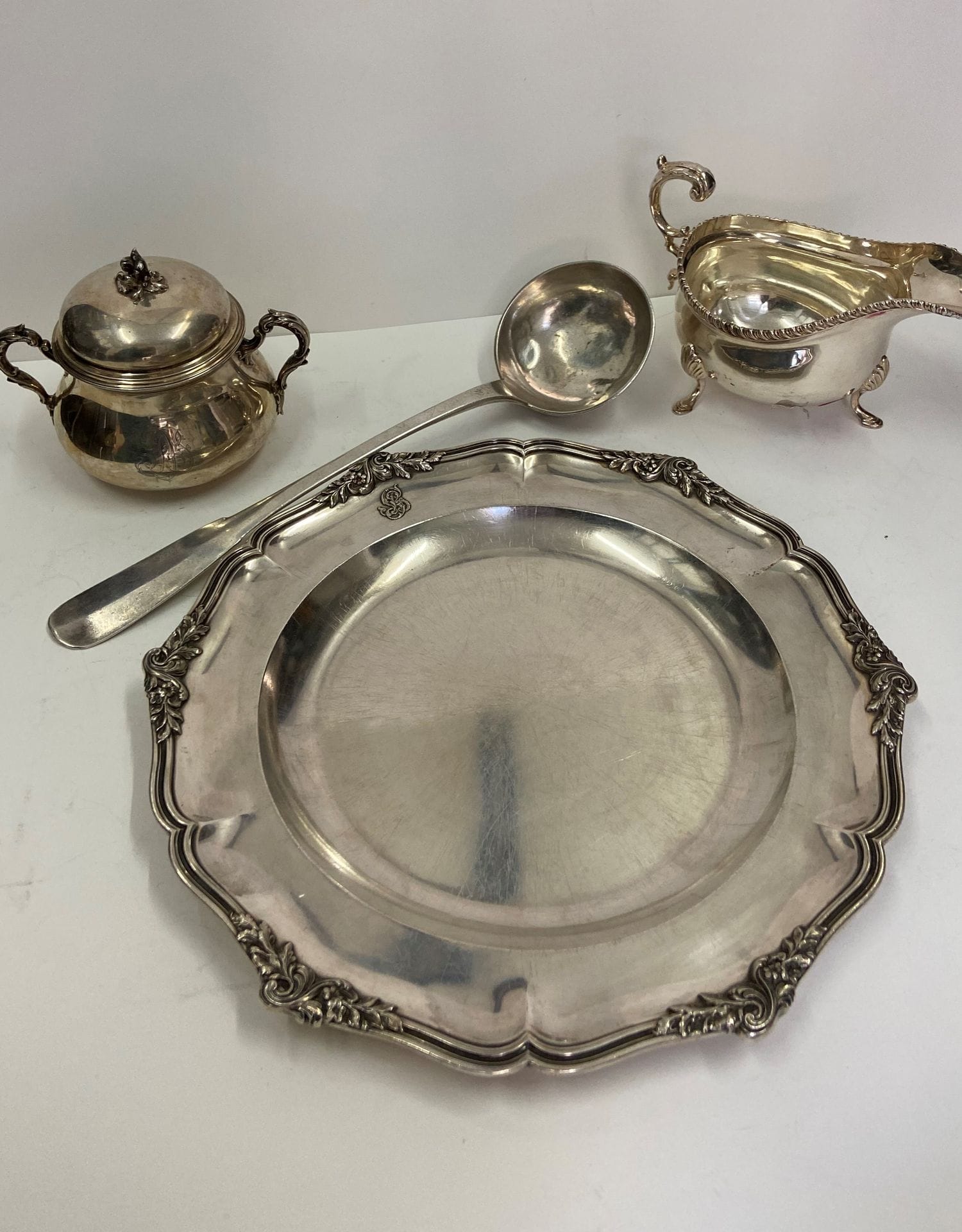 Fort lot d'argenterie. XVIIIe et XIXe siècle. Poids : 8701 g 
- 11 plats comprenant des plats de présentation, assiettes et jattes en argent. Poids: 7894 g 
- 1 pot à lait . Poids: 314 g
- 1 louche. Poids: 219 g 
- 1 sucrier. Poids : 274 g