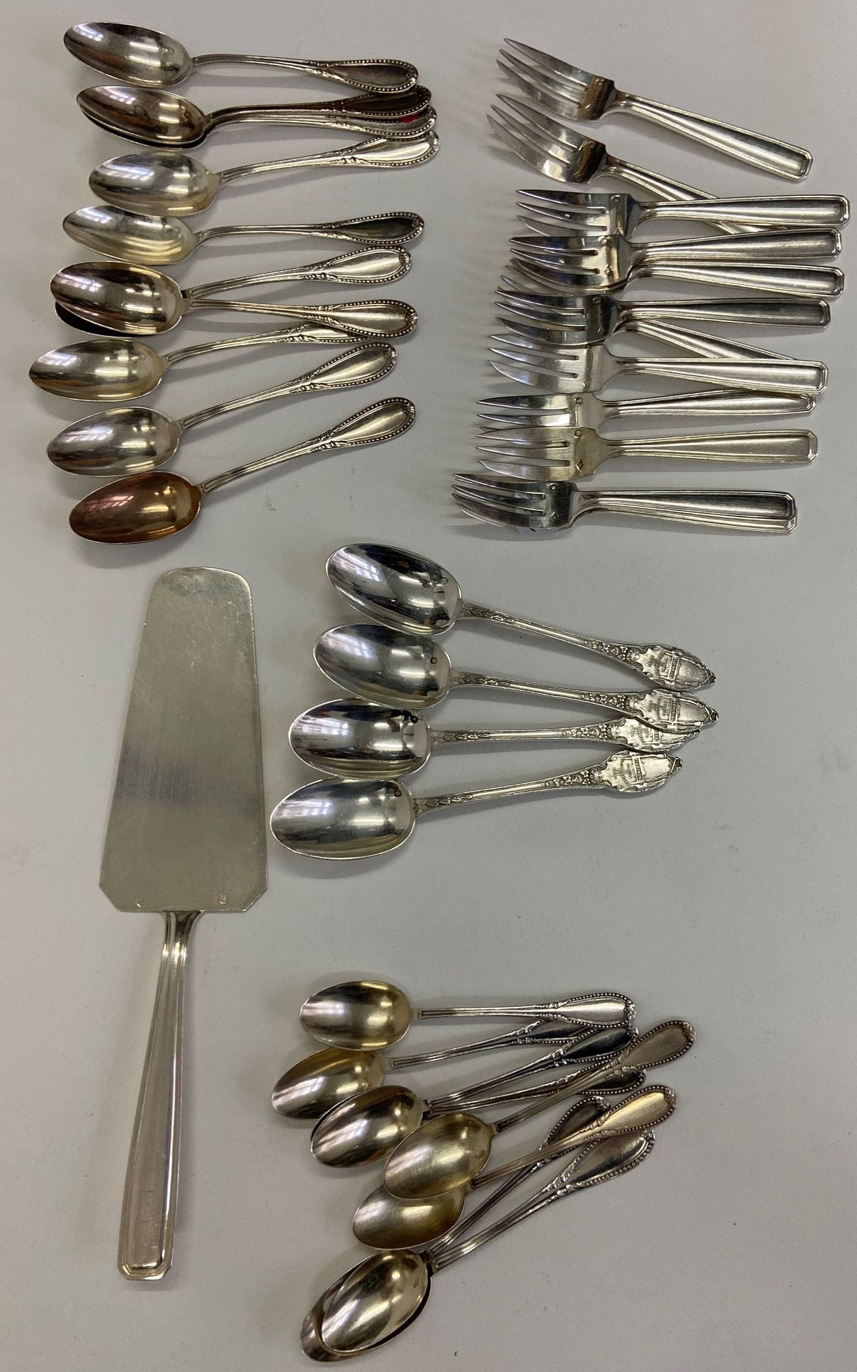Lot de couverts en argent. Poids : 753 g.
- 22 petites cuillères (dépareillées), 
- 12 fourchettes à fruits, 
- 1 pelle à tarte.
