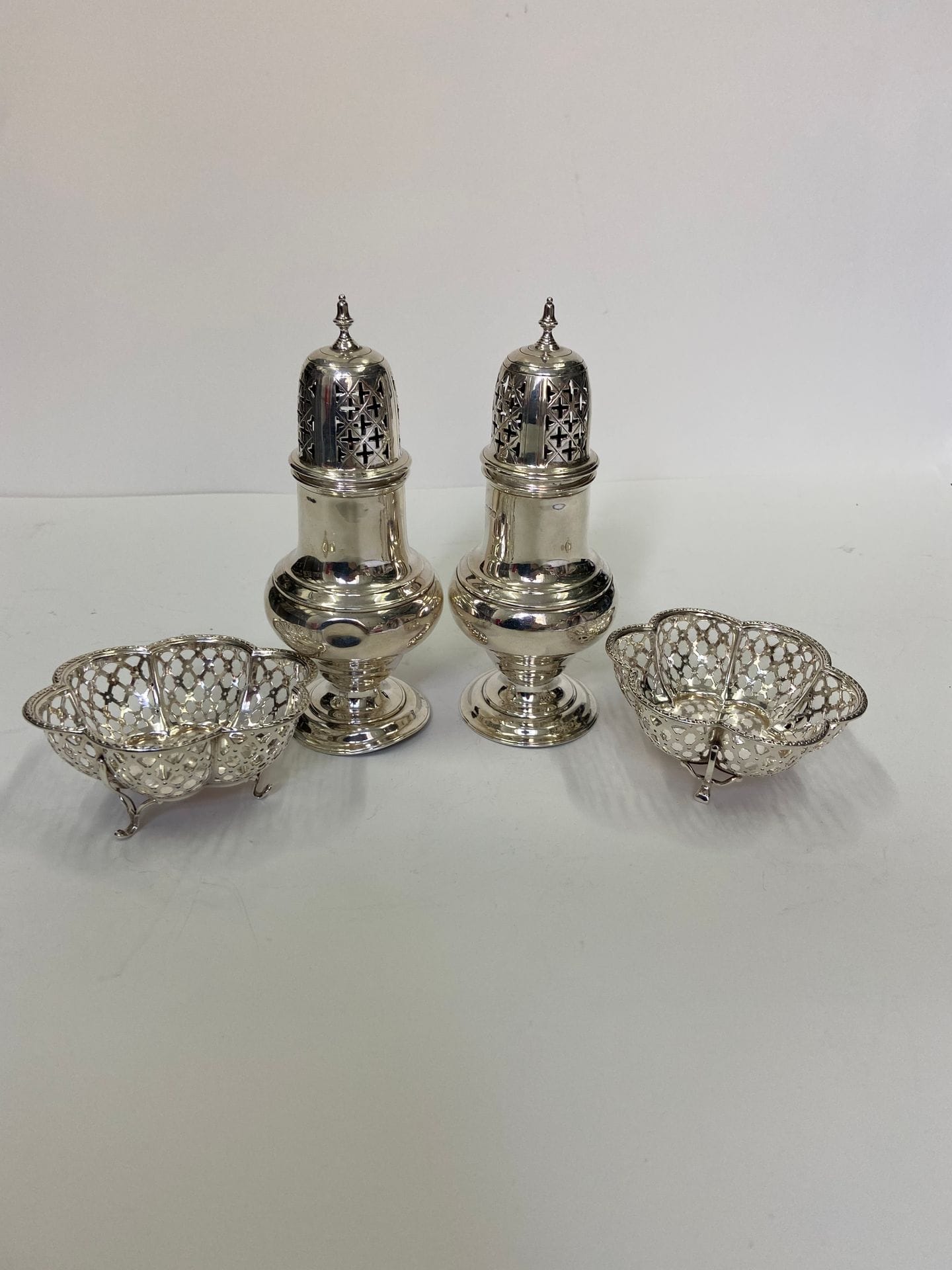 Lot de 4 pièces en argent. Poids: 345 g
- 2 saupoudreuses en argent. Poids: 237 g 
- 2 petites coupes sur pieds, ajourées. Poids: 108 g