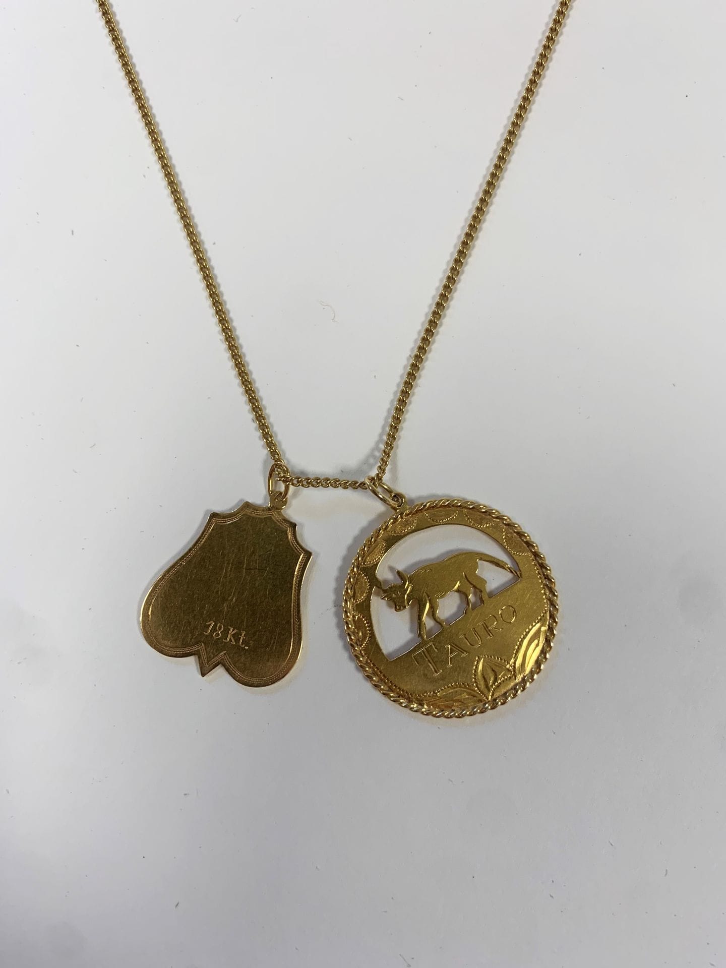 Longue chaine en or (18K) et pendentif signe du zodiac "Taureau" (18K). Poids : 13,2 g
On joint un pendentif "Shaddaï". Poids : 2,1 g