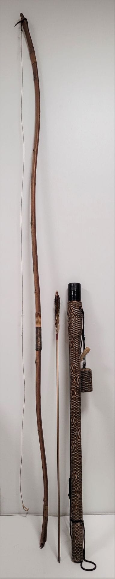 Arc Yumi de kyudo, Japon, XXe siècle
En bambou lamé et collé. Trace de signature de fabrication. 
Hauteur avec corde : 215 cm ; hateur sans corde : 220 cm
Carquois en vannerie avec dix flèches de longueurs différentes dont neuf en bambou et une en métal.