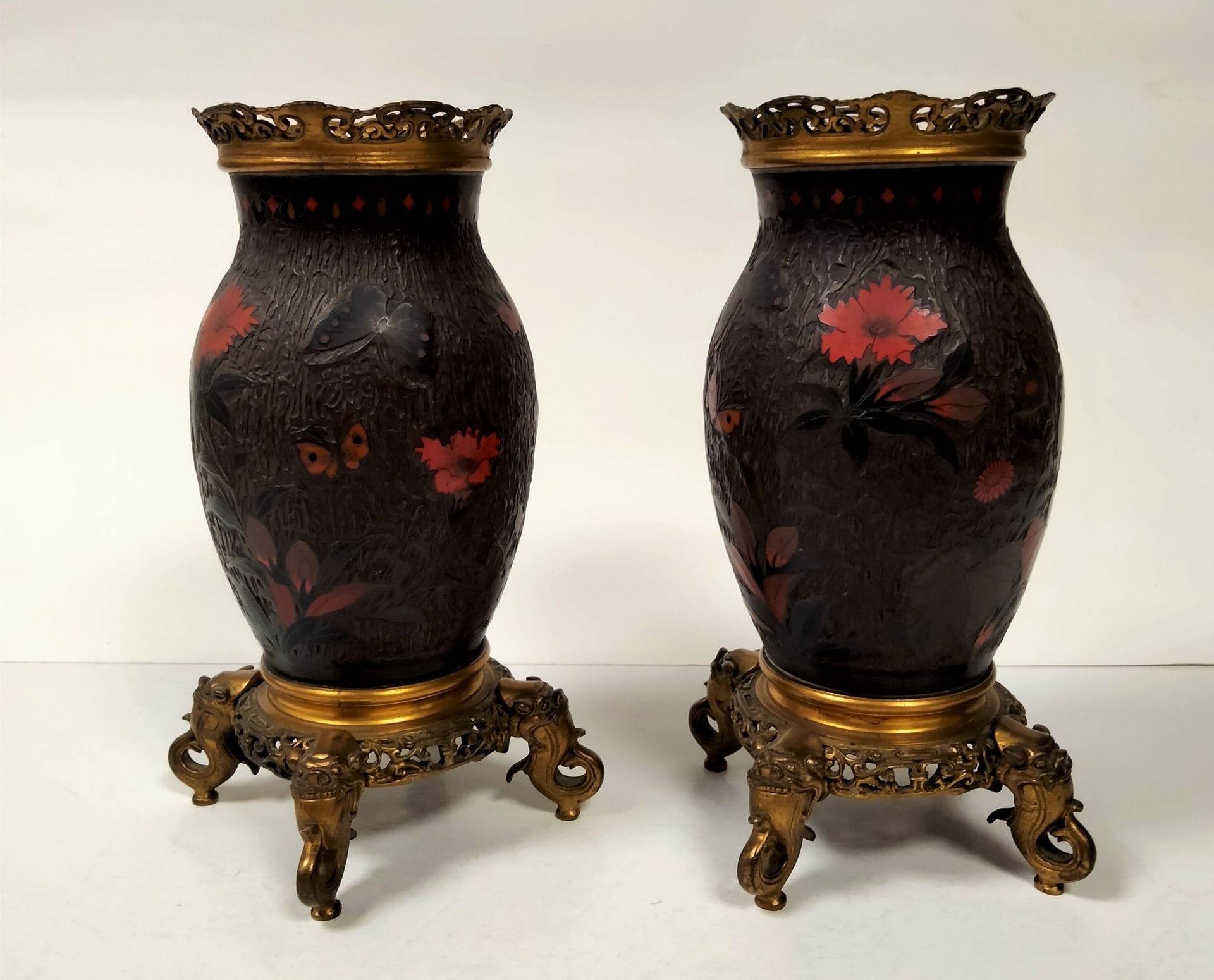 Pair of lacquered porcelain vases, Japan, circa 1900A
cloisonné decoration of flowers and butterflies on a tree bark effect background. Mounted in gilt bronze, quadripod base, the feet forming a chimera with an open mouth. 
Height: 23 cmSmall
missing parts.


