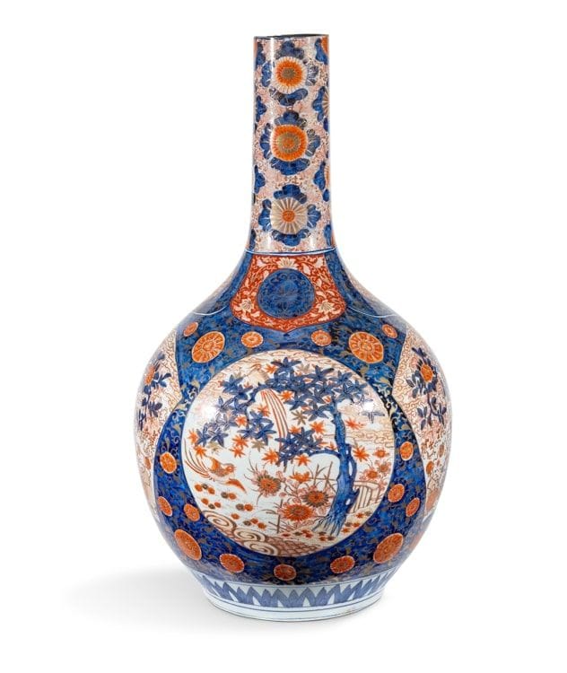 A large porcelain bottle vase with Imari decoration, Japan, Meiji period (1868-1912
)With spherical body and high neck, decorated with chrysanthemums and foliage on a blue background and reserves decorated with flowering baskets on a background of foliage and clouds.
Height: 80
cmRolled
neck
, small chips, small hole in the body
.


