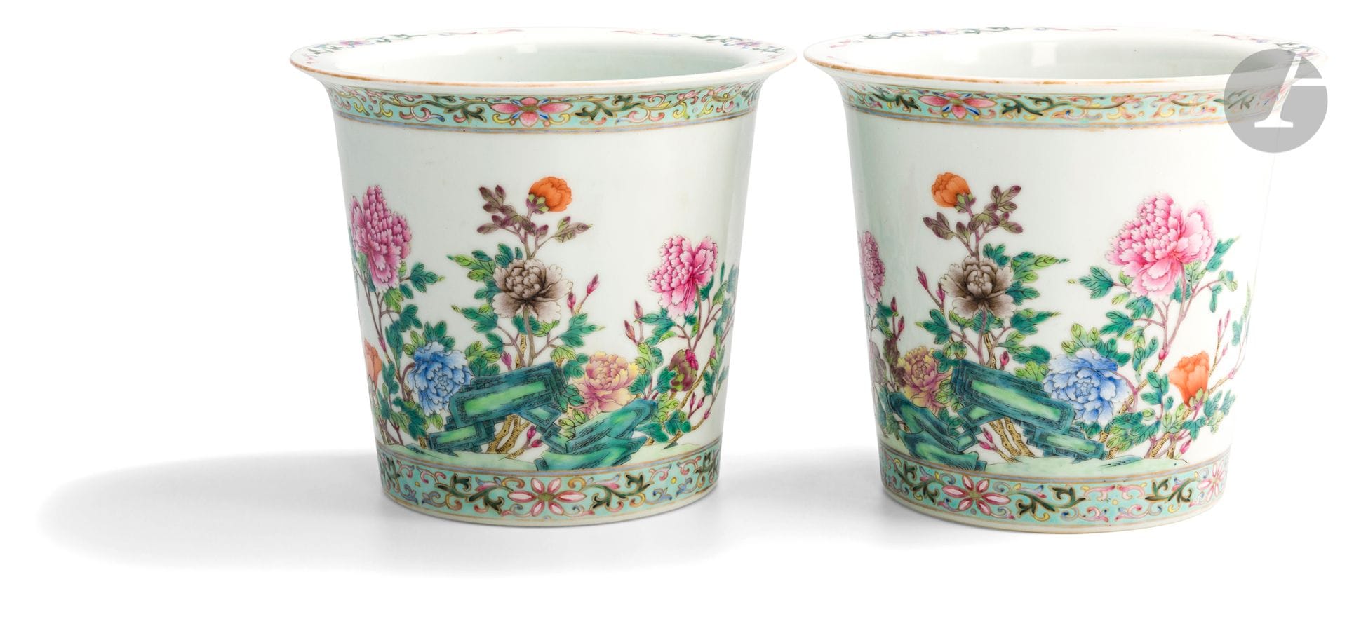 Paire de jardinières de forme cylindrique en porcelaine émaillée dans le style de la famille rose, Chine, début XXe siècle
À décor continu de pivoines et rochers, et de deux bordures de rinceaux fleuris sur fond bleu turquoise autour du pied et du haut des jardinières. Marque apocryphe Jiaqing en rouge sur couverte à la base.
Hauteur : 20,5 cm ; diamètre : 23 cm
Deux trous percés d’origine dans le fond.
