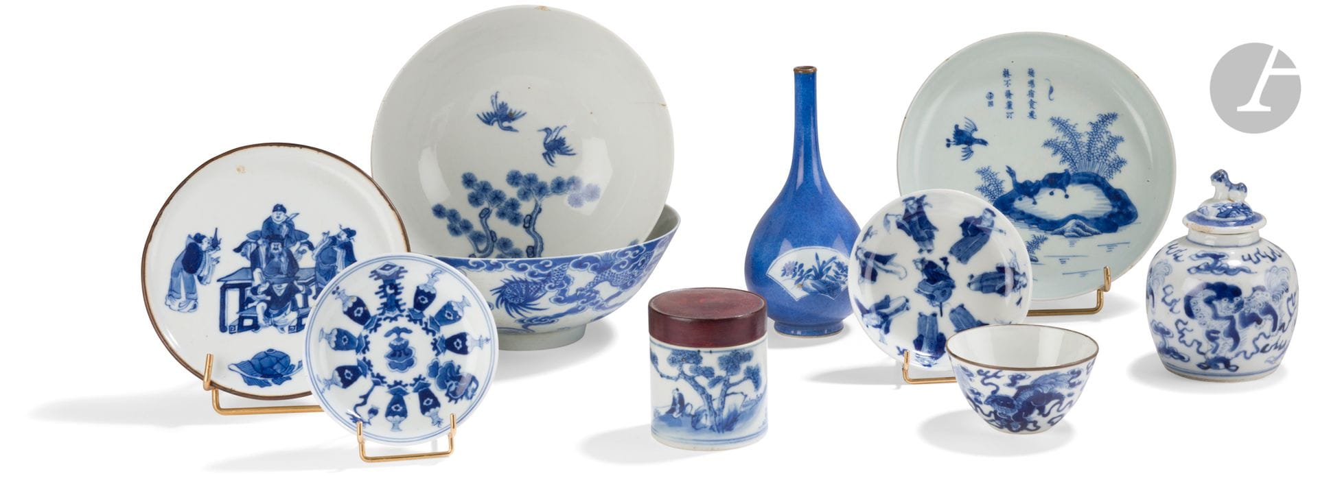 Neuf porcelaines bleu et blanc, Chine pour le Vietnam, XIXe siècle, et un petit vase bleu et blanc, Chine, époque Kangxi (1654-1722)
- Bol à décor d’un dragon à trois griffes soufflant des flammes au-dessus des flots écumants, accompagné d’une kirin, le joyau sacré au milieu des nuages. Marque ÈÕ - nhật (rì en chinois) - soleil, utilisée sous le règne des empereurs Minh Mạng (明命帝1820-1841), Thiệu Trị (紹治帝 1841–1847) et Tự Đức (嗣德帝 1847-1883). Diamètre : 18,4 cm ; hauteur : 7 cm ; nombreux fêles.
- Bol orné à l’extérieur de deux daims, l’un sous un pin près d’un rocher et l’autre sous la lune dans des nuages et de deux chauves-souris en vol. Des pins et deux grues à l’intérieur du bol. Marque Tân Mùi Tự Đức - 辛末嗣德 (en chinois : Xinwei Tu Duc), date cyclique 24ème année du règne de Tu Duc 1871, en vietnamien Tân Mùi Tự Đức. Diamètre : 17,8 cm ; hauteur : 7 cm ; fêles et égrenures.
- Petit plat à décor dit aux quatre oies - « phi minh túc thực », les volatiles symbolisant par leurs attitudes (le vol, le chant, le logement et la nourriture) « vivre dans la paix et le contentement » et « paix dans le monde ». Au-dessus, le poème 飛鳴宿食慮終不捨蓋汀qui pourrait se traduire par: voler, crier, se reposer, manger ne devrait être finalement que la seule préoccupation sur la berge au bord des roseaux. Marque Ngoan Ngoc -玩玉(wàn yù) - « bibelot de jade ». Diamètre : 17,3 cm
- Petite coupelle à double décor des huit immortels taoïstes - 利記豊泰- « Phong Thai Loi Ky », l’un à l’intérieur et l’autre sur le bord extérieur. Marque 豊泰利記- Lǐ tài lì jì. Diamètre : 10,7 cm
- Petite coupelle à décor de vases, d’un porte-lanterne et d’une kirin. Trois chauves-souris stylisées à l’extérieur. Marque Qianlong apocryphe. Diamètre : 10,3 cm
- Petit sorbet à décor de quatre chiens de Fô jouant avec des balles de brocart parmi des nuages stylisés. Marque 金玉鋒記 - Jīn yù fēng jì - « recueil intime du jade d’or ». Cerclage en métal. Diamètre : 8,2 cm ; hauteur : 4,5 cm
- Petit plat à décor central de six personnages autour d’une table et, au premier plan, d’un vase et d’une feuille de bananier. Marque 陶玉選庄 - Táo yù xuǎn zhuāng - « sélection de céramiques précieuses comme le jade ». Bord rodé et cerclé de métal. Diamètre : 15 cm
- Petit pot cylindrique à décor d’un pêcheur sous un pin. Couvercle en bois. Hauteur : 6,4 cm
- Petit vase couvert de forme globulaire à décor de trois chiens de Fô dans des nuages stylisés. Couvercle rapporté à décor d’un personnage dans un sampan et de pavillons, la prise en forme de chien. Marque Kangxi apocryphe. H. totale : 12 cm ; égrenure au couvercle.
- Petit vase bouteille orné de deux cartouches, l’un polylobé et l’autre en forme d’éventail, décorés de fleurs et rochers. Le haut du col cerclé de métal. Chine, époque Kangxi (1662-1722). Hauteur : 16 cm