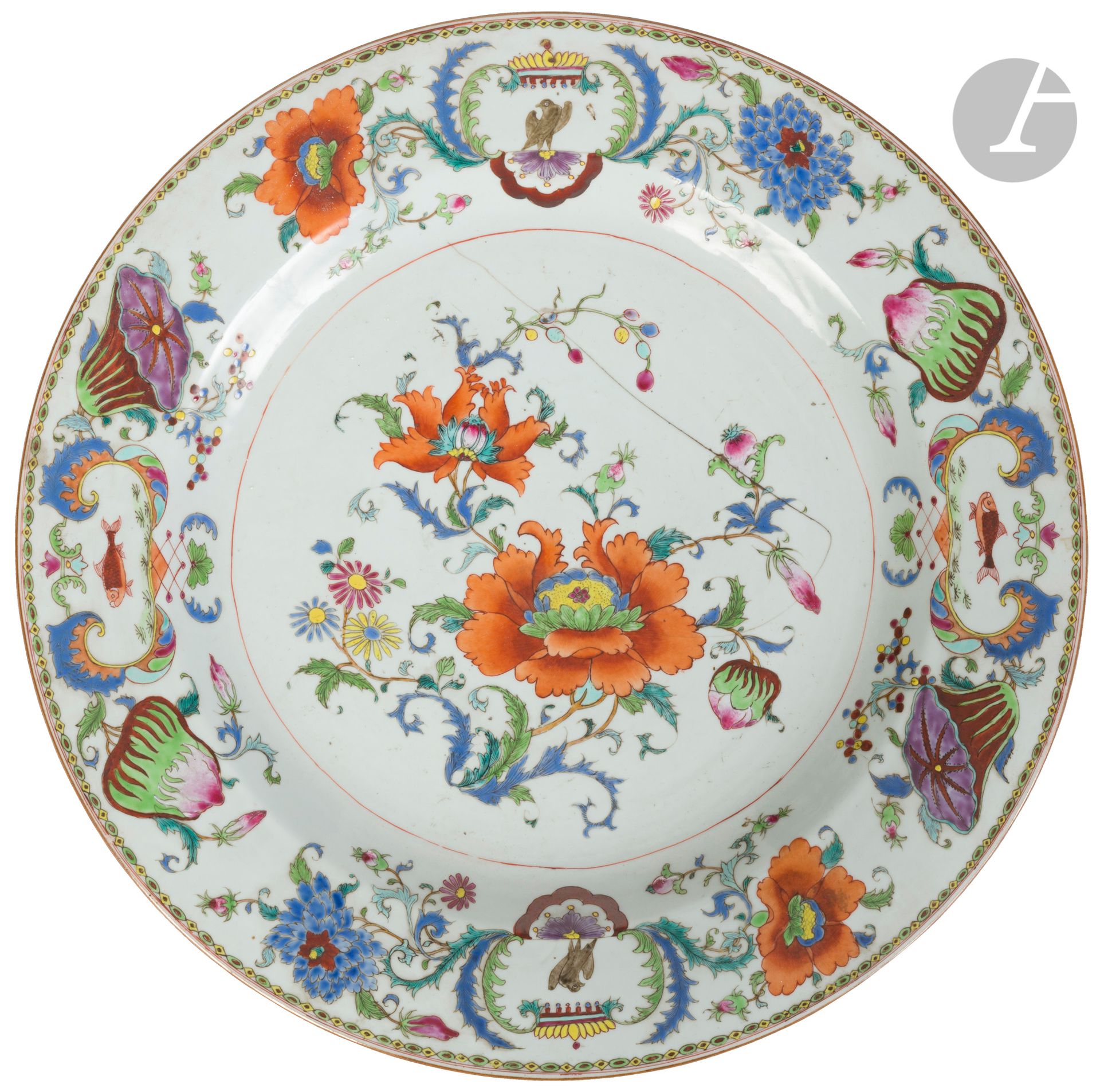 Grand plat en porcelaine de la famille rose à décor dit « Pompadour », Chine, Compagnie des Indes, XVIIIe siècle
Émaillé en polychromie à dominante bleue, le centre à décor de pivoines et chrysanthèmes dans un médaillon central et le marli orné de pivoines, de lotus et de quatre cartouches alternés, aux armes d’un aigle et d’un poisson. Au revers, trois branches fleuries en rouge de fer.
Diamètre : 47 cm
Grande fêlure centrale. 

Depuis le XIXe siècle, on a historiquement attribué la commande de ce service à la célèbre maîtresse du roi Louis XV, la marquise de Pompadour. L’association d’un aigle et d’un poisson dans un cartouche pouvant symboliser respectivement le roi Louis XV et la marquise de Pompadour dont le patronyme était Poisson. Cette hypothèse fut mise en doute par Michel Beurdeley, grand spécialiste de la porcelaine de Chine, considérant que la marquise de Pompadour n’aurait certainement pas commandé un service dont les éléments du décor puissent rappeler ses origines plébéiennes. Ce service existe aussi dans deux autres versions, en bleu sous couverte et en polychromie à dominante rouge.