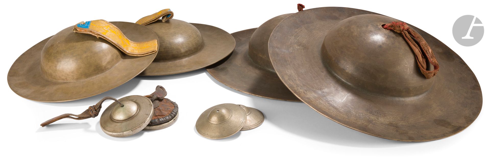 Quatre paires de cymbales en alliage sonore, Tibet, XIXe siècle
- Une paire rölmo sans décor avec une lanière de textile jaune brodé.
- Une grande paire rölmo sans décor avec une lanière de textile ocre-rouge.
- Une petite paire ting-çags (tingsha) gravés de rinceaux à l’extérieur et de dragons et vajra à l’intérieur.
Diamètre : de 8 à 36,5 cm