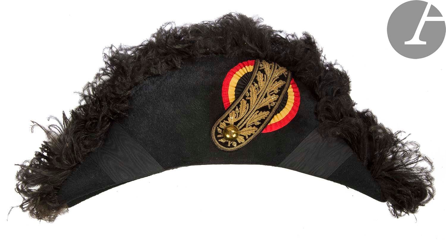 Bicorne clac d'ambassadeur ou de haut fonctionnaire belge. 
En feutre taupé garni de plumes noires. Ganse en velours noir brodé de canetille et paillettes dorées. Cocardes aux couleurs belges. Bouton doré, uni. Intérieur avec marque de fabricant de Gagean, « Chapelaria da Moda » à Lisbonne. 
Dans sa boîte. 
B.E. Début du XXe siècle.