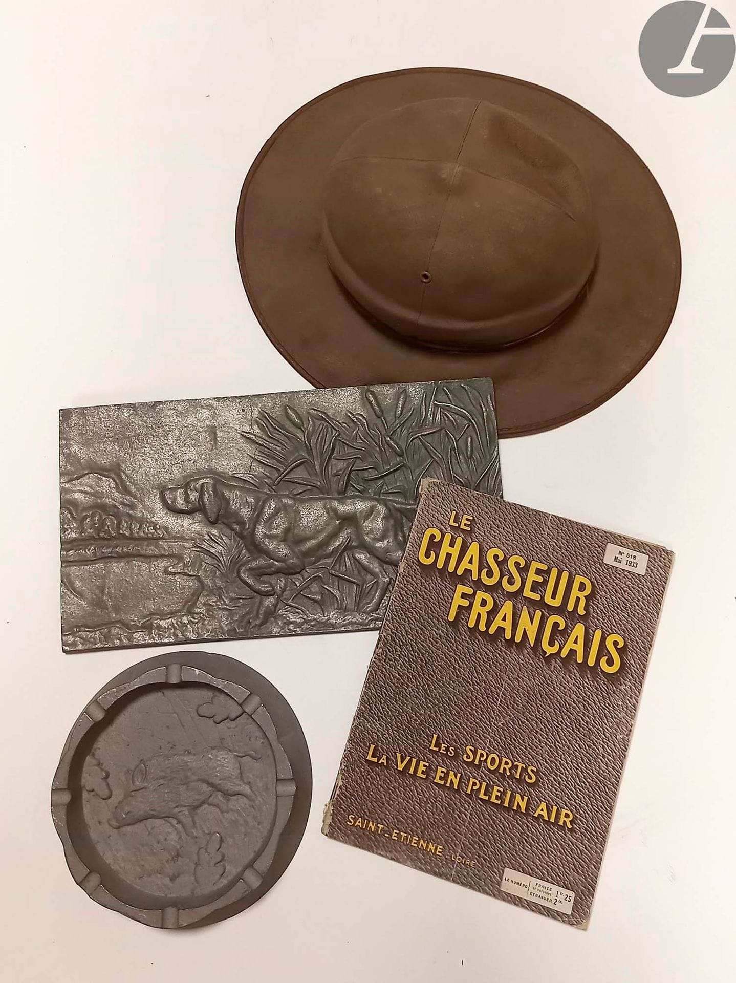Le chasseur français.
« Les sports, la vie en plein air ». Catalogue mai 1933.
On y joint :
Un cendrier en aluminium à décor d’un sanglier. Diamètre : 16 cm
Un chien de chasse « Epagneul dans le roseau » en aluminium. 18 x 33 cm
Un chapeau colonial recouvert de toile kaki bordée de cuir. État d’usage.