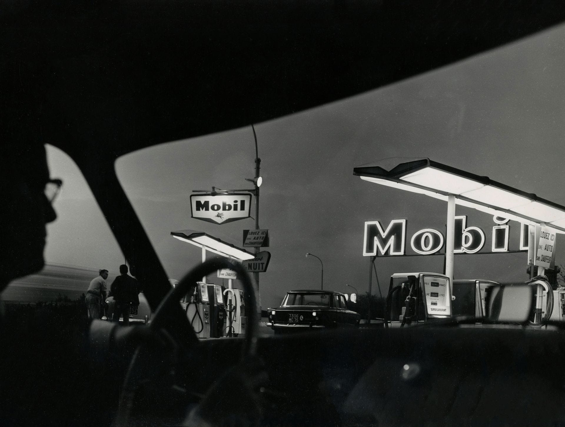 Christian Lemaire (1932)
Station service Mobil au crépuscule. Chartres, 1965.
Épreuve argentique d'époque, signée, titrée et datée à l'encre avec le tampon du photographe au verso. 
27,8 x 37,4 cm

Christian Lemaire (1932)
Mobil service station at dusk. Chartres, 1965.
Vintage gelatin silver print, signed, titled and dated in ink. Photographer's stamp on verso. 
27.8 x 37.4 cm