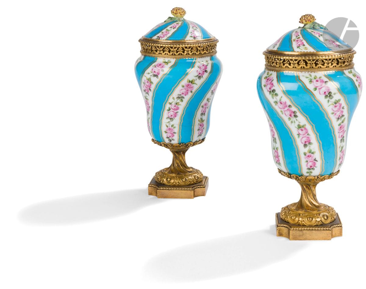 Paire de vases pot-pourri en porcelaine à monture de bronze doré ajourée de feuillages, reposant sur un piédouche à cannelures torses et base échancrée ; (petits accidents et restaurations).
Premier tiers du XIXe siècle.
H : 25 cm